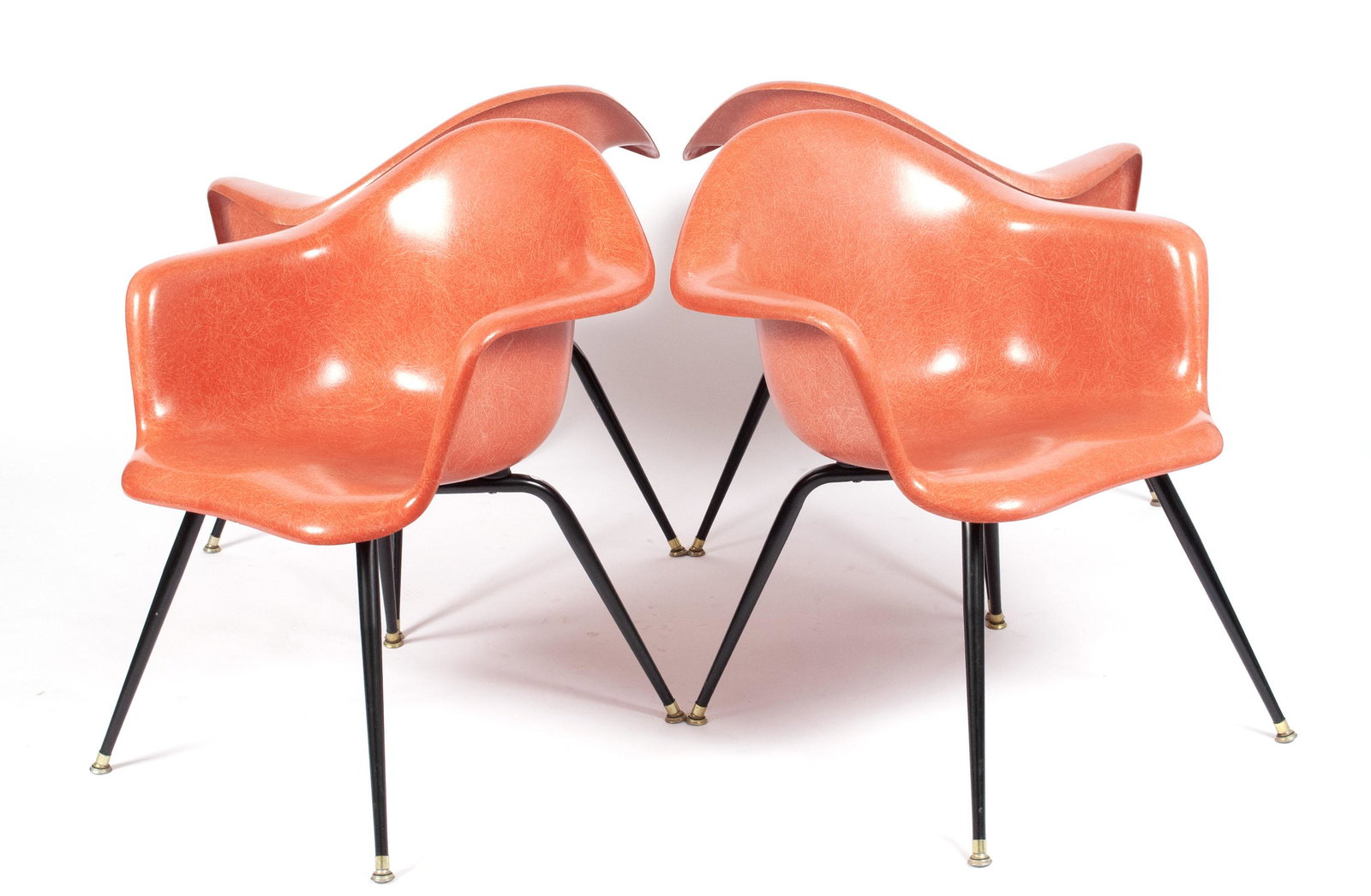 FOUR CHROMCRAFT FIBERGLASS ARMCHAIRS: FOUR CHROMCRAFT FIBERGLASS ARMCHAIRSAmerican, mid-20th century, fiberglass. In the style of Eames, the fiberglass shells in bright salmon, raised over tapering, slender x-form legs.30 x 26 x 22 in. (7