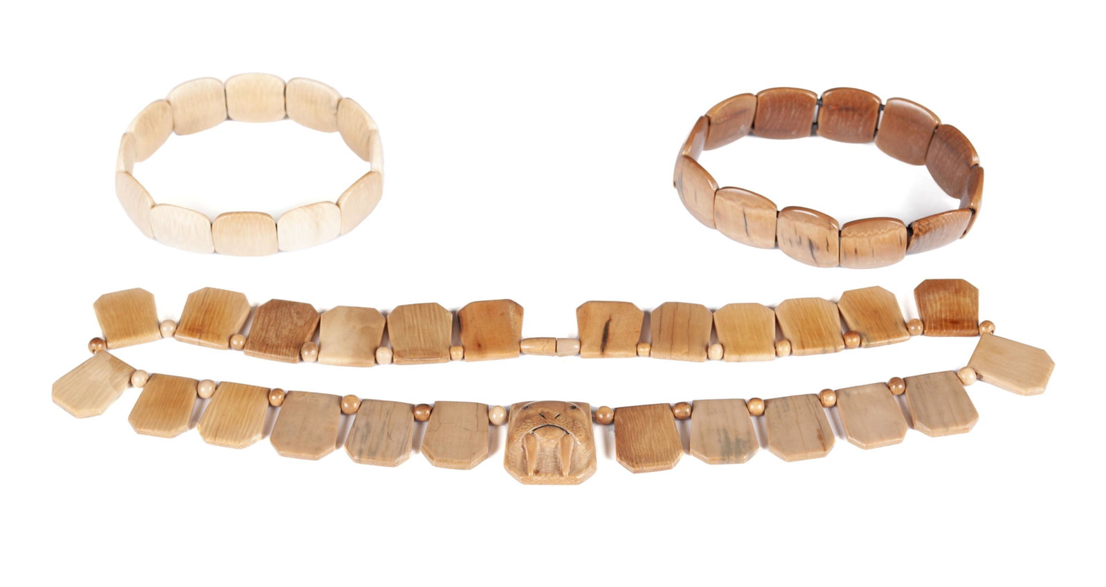 INUIT MASTADON JEWELRY: INUIT MASTADON JEWELRY Alaskan (Reindeer People), c. 1900, mastodon tusk core. A necklace beaded of tusk tablets and smaller beads centered by a relief carved walrus tablet, together with two similar 