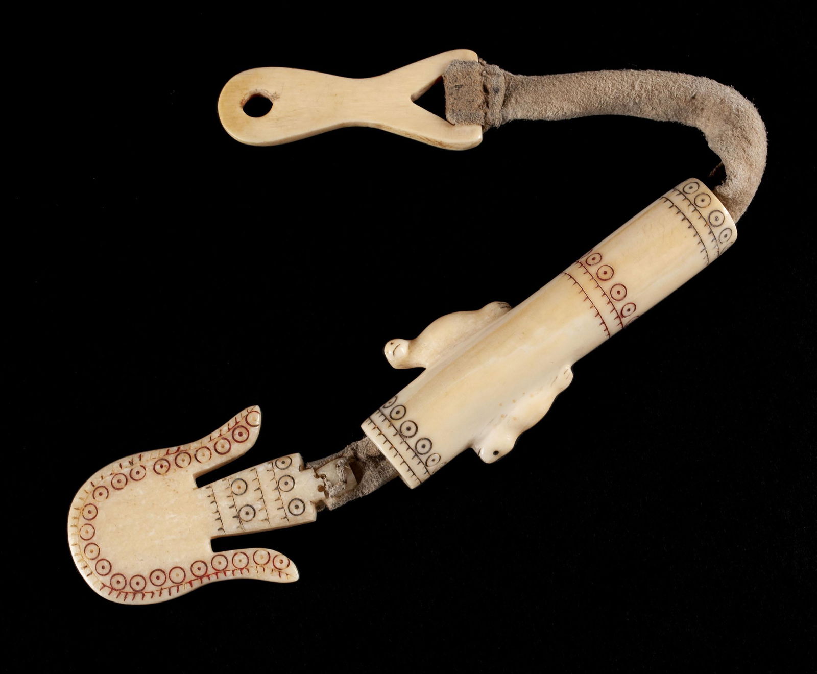 AN INUIT CARVED SEWING KIT: AN INUIT CARVED SEWING KITAlaskan (Reindeer People), c. 1900, organic material. Needle case incised and pigmented in black and red, the cylindrical case portion carved with two figural seals and strun