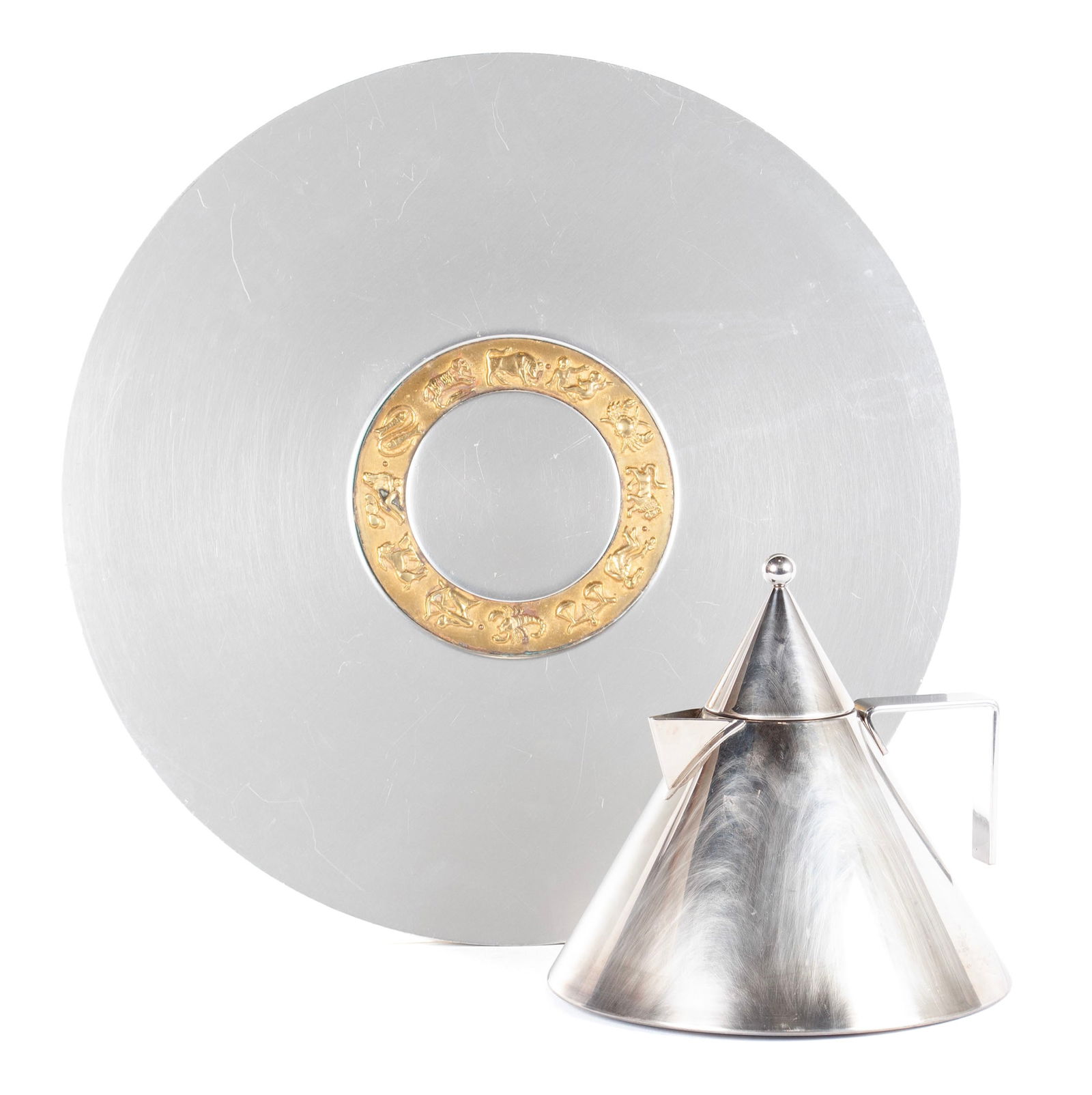 ALDO ROSSI 'ALESSI' TEAPOT & KENSINGTON ZODIAC CHARGER BY LURELLE GUILD: ALDO ROSSI 'ALESSI' TEAPOT & KENSINGTON ZODIAC CHARGER BY LURELLE GUILDItalian, 20th century, stainless steel and aluminum. The Alessi tea or coffee pot of conical form coming to a point at the lid. T
