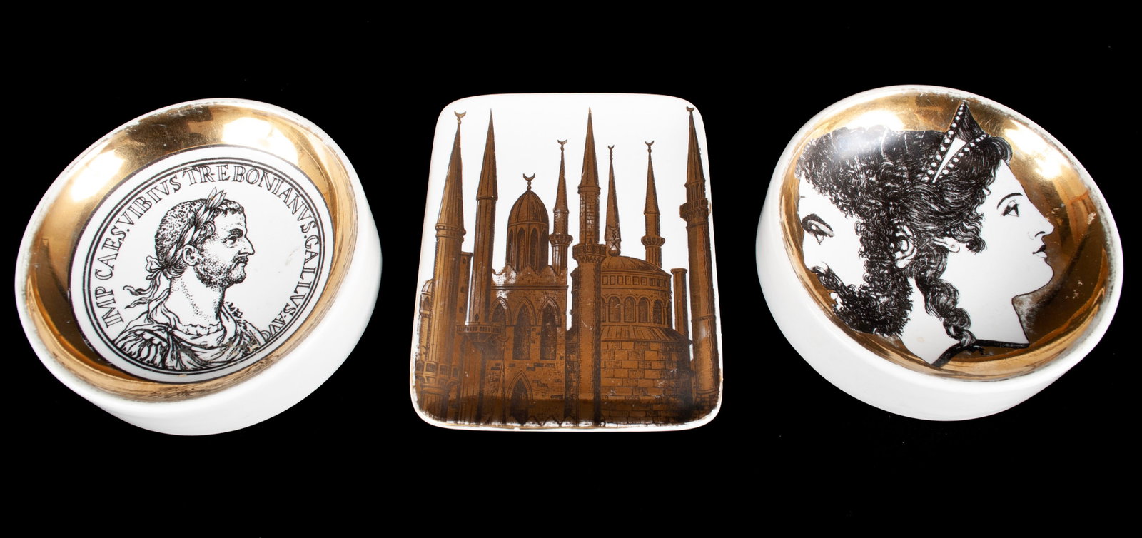 TRIO OF PIERO FORNASSETTI PORCELAIN: TRIO OF PIERO FORNASSETTI PORCELAIN Italian (Milano), 20th century, porcelain. Three (3) gilt-adorned dishes: two ashtrays, one with classical image of Roman Emperor Trebonianus Gallus "Imperator