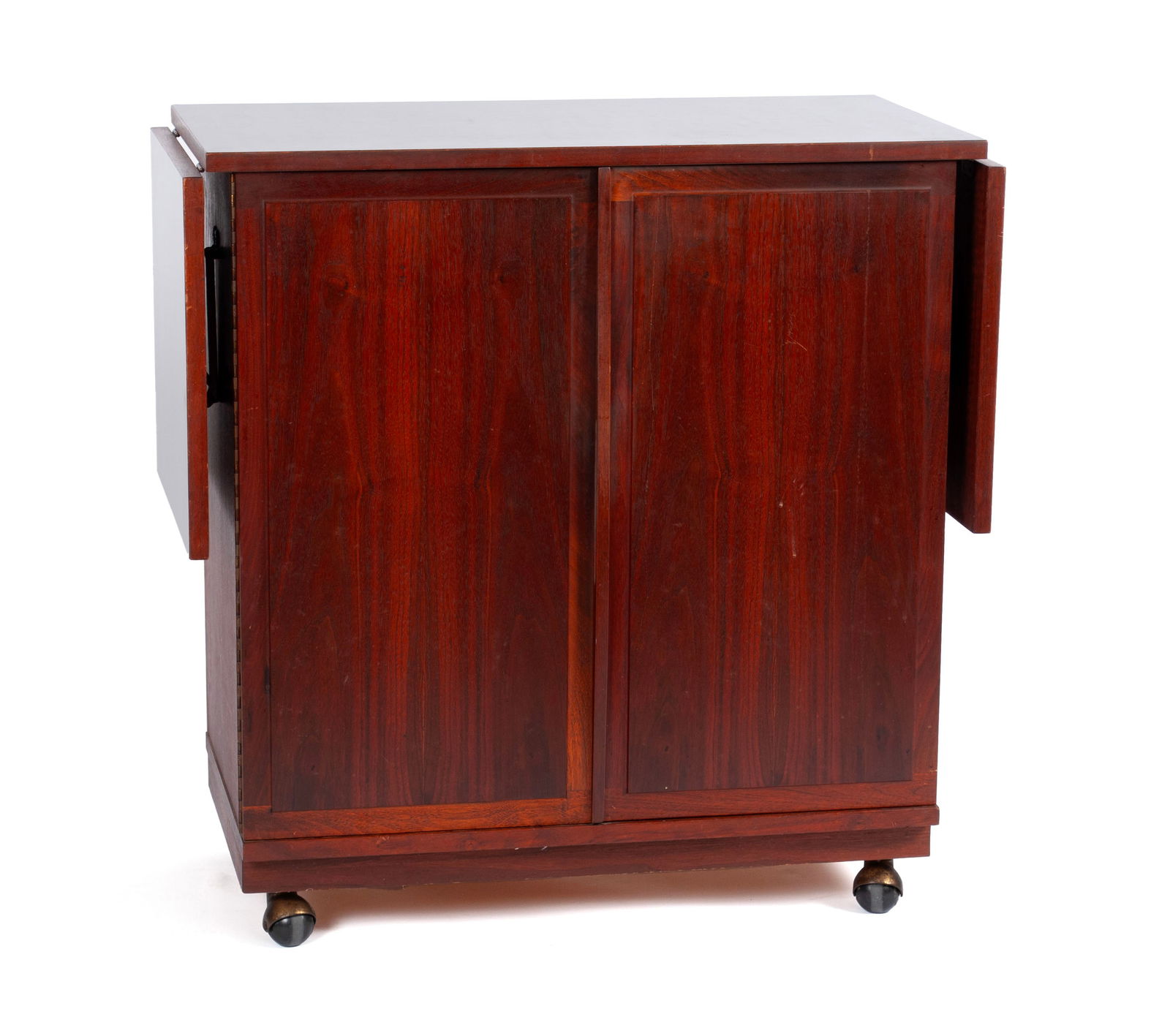 JACK CARTWRIGHT DESIGNED MODERN BAR CART: JACK CARTWRIGHT DESIGNED MODERN BAR CARTAmerican, 20th century, mahogany. Black laminate top with twin drop leaves, full length cupboard doors over the fitted interior with drawers and storage.34 1/2