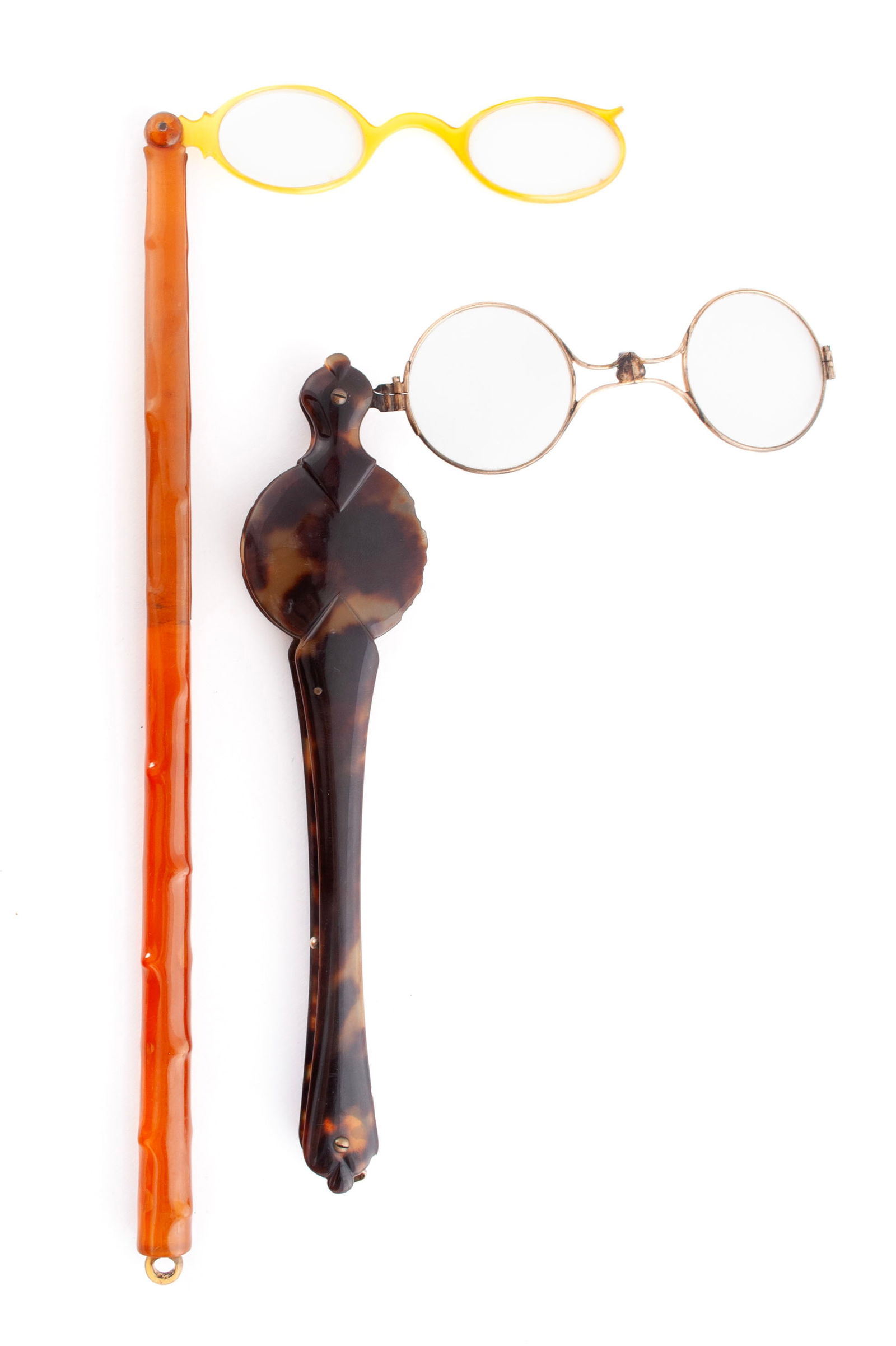 TWO LORGNETTES: TWO LORGNETTESOne American Sturbridge, circa 1880, of tortoiseshell with spring action release of spectacles with round lenses. The other Belgian of amber tortoise, circa 1890.From the collection of D