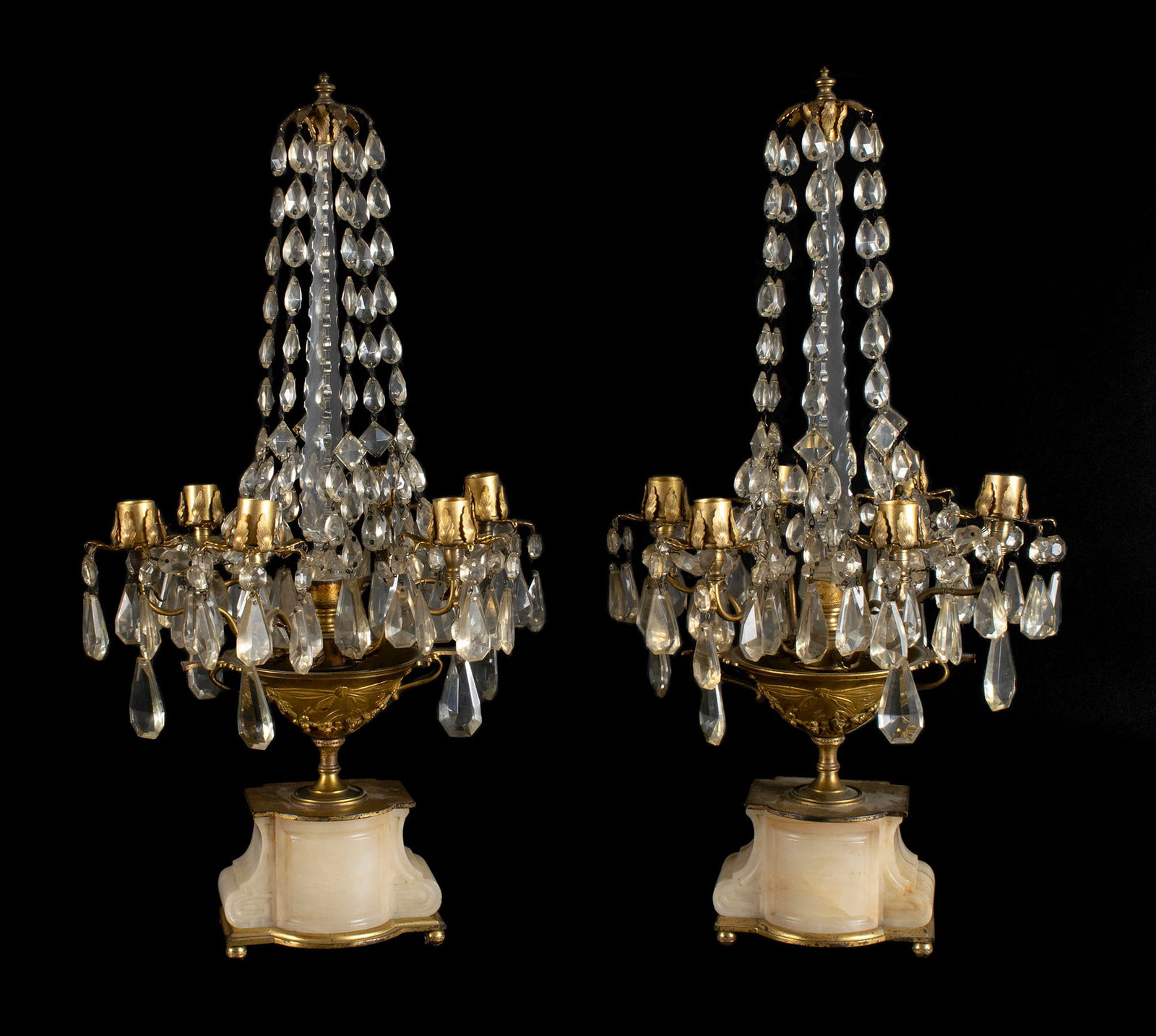 PAIR OF GIRANDOLES: PAIR OF GIRANDOLES Continental, early 20th century. Central prismatic support holds lines of prisms down to the urn form supports with six candle holders each, on the shaped onyx bases. 21 1/2 x 11 in