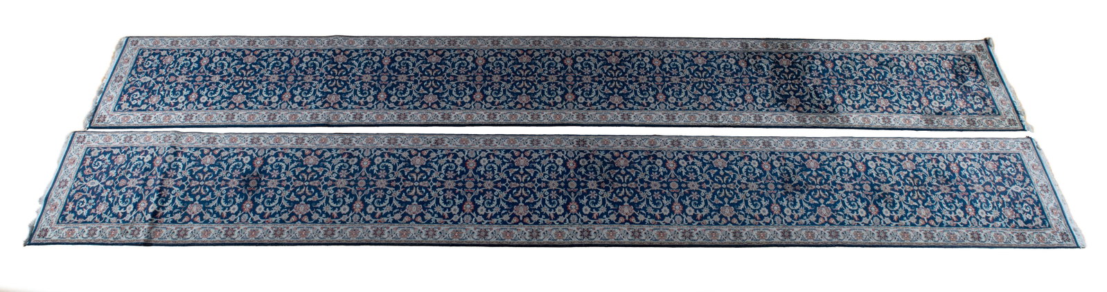 PAIR OF NAIN LONG RUGS: PAIR OF NAIN LONG RUGS Persian, 20th century. Navy fields are covered with flowering vines, floral decorated ivory borders. Nearly identical sizes. Longest: 19 ft. 11 in. x 2 ft. 6 in.