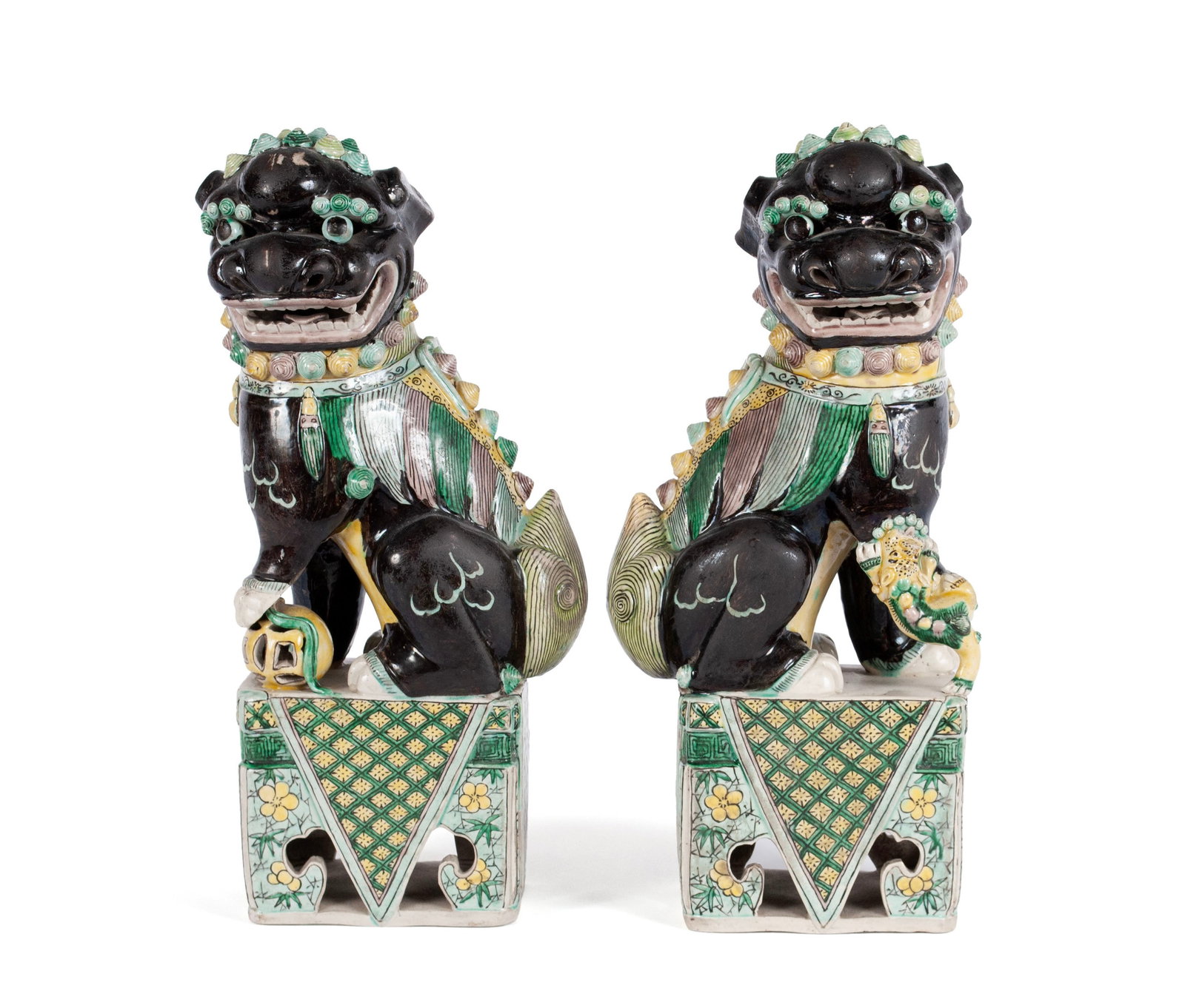 PAIR OF PORCELAIN FOO DOGS: PAIR OF PORCELAIN FOO DOGS 20th century. Decorated in black, green, pink and yellow, raised on square, pierced bases. 15 x 4 x 6 1/2 in. (38.1 x 10.2 x 16.5 cm.)