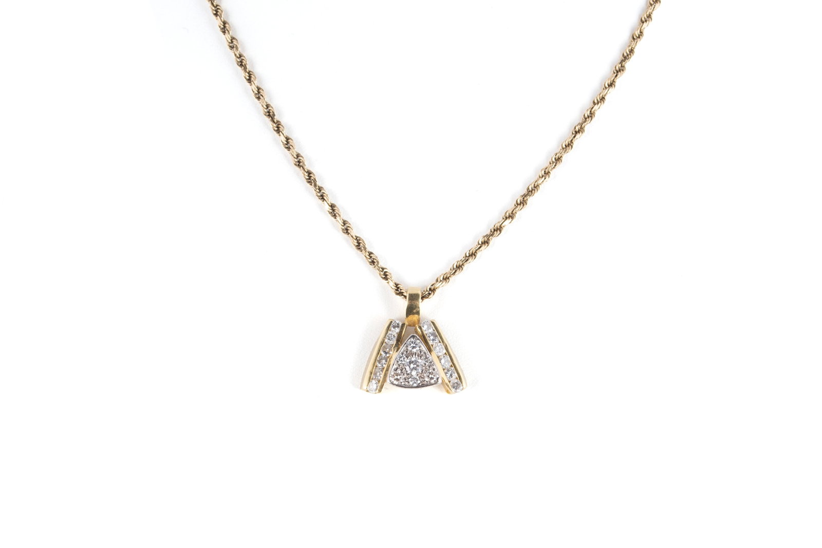 YELLOW GOLD AND DIAMOND PENDANT NECKLACE: YELLOW GOLD AND DIAMOND PENDANT NECKLACE A 14k gold pendant with a triangle of seven (7) inset round brilliant diamonds flanked by two rows of round brilliant diamonds, six to each side. Diamonds weig