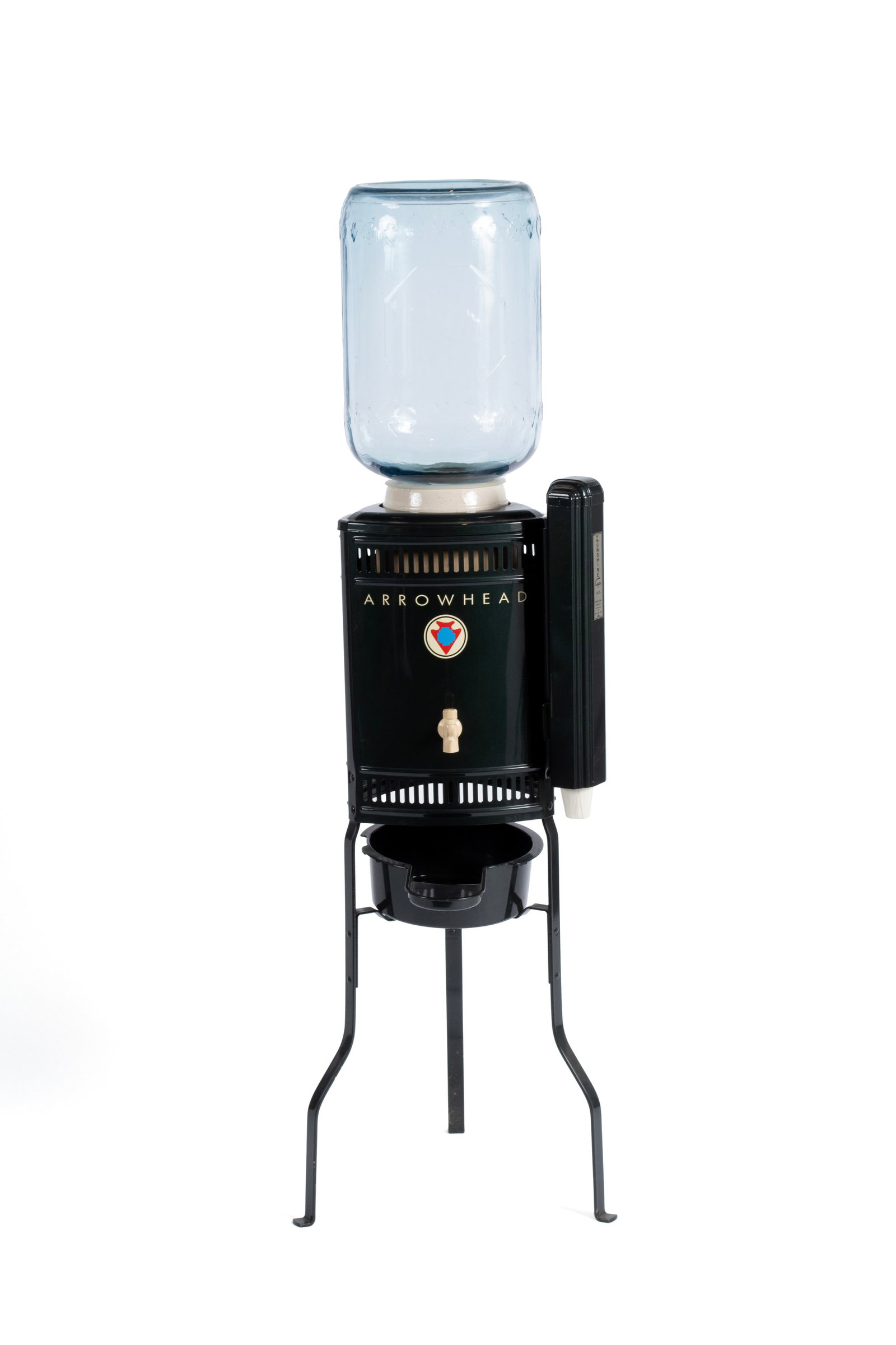 ARROWHEAD WATER COOLER: ARROWHEAD WATER COOLER American, third quarter 20th century, metal with composite parts. Forest green triangular form casing with "ARROWHEAD" across the front, cup dispenser mounted to one side, on tr