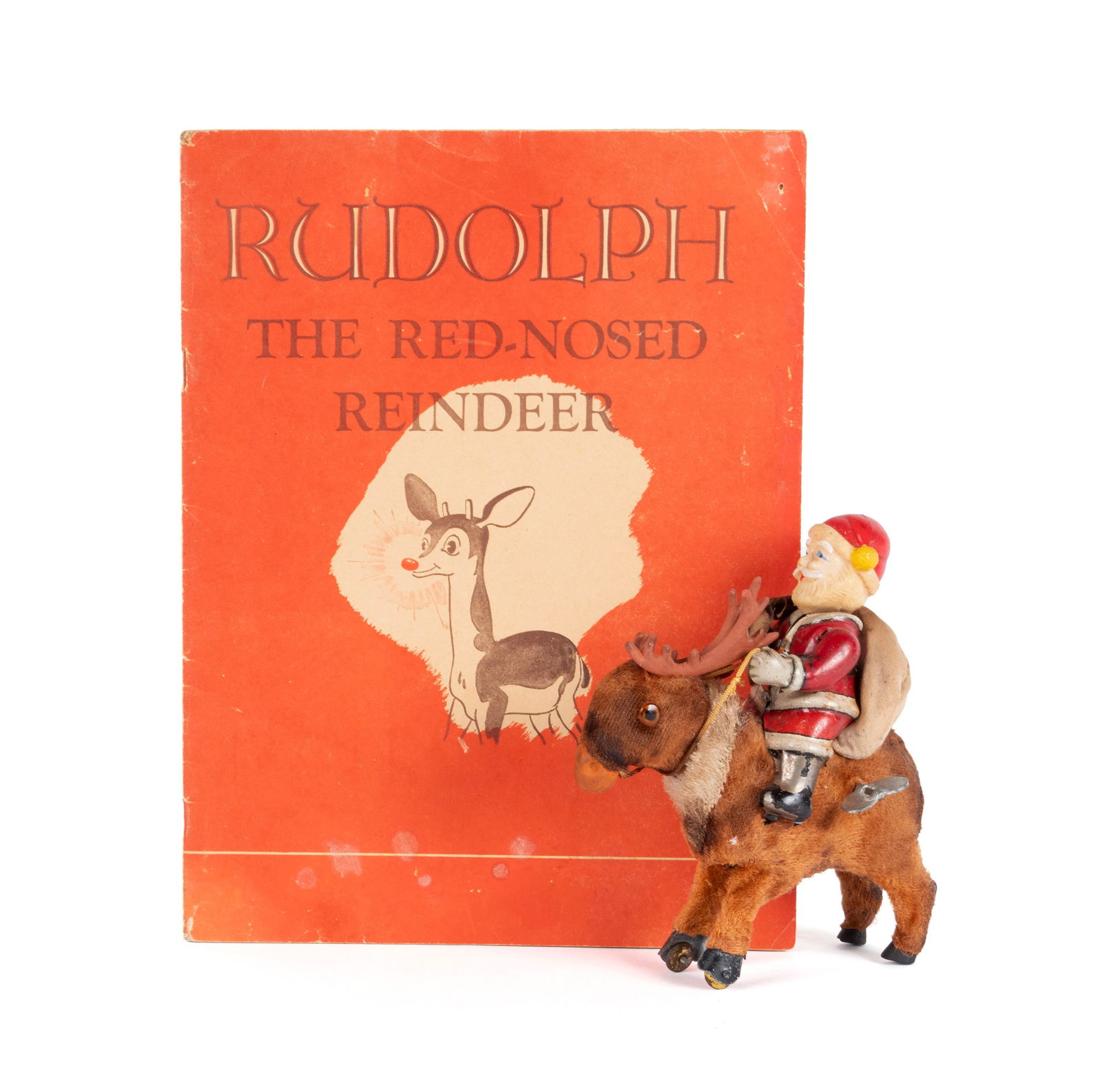 FIRST EDITION RUDOLPH THE RED-NOSED REINDEER AND A JAPANESE WINDUP SANTA ON REINDEER: FIRST EDITION RUDOLPH THE RED-NOSED REINDEER AND A JAPANESE WINDUP SANTA ON REINDEERAmerican, by Robert L. May, copyright 1939, published by Montgomery Ward & Co., and illustrated by Denver Gillen, to