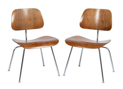 CHARLES AND RAY EAMES FOR HERMAN MILLER PAIR OF 'DCM' DINING CHAIRS: CHARLES AND RAY EAMES FOR HERMAN MILLER PAIR OF 'DCM' DINING CHAIRSMid 20th century, molded plywood and chromed steel frames. Paper label to underside of both, one (1) with the circular "Designed by C