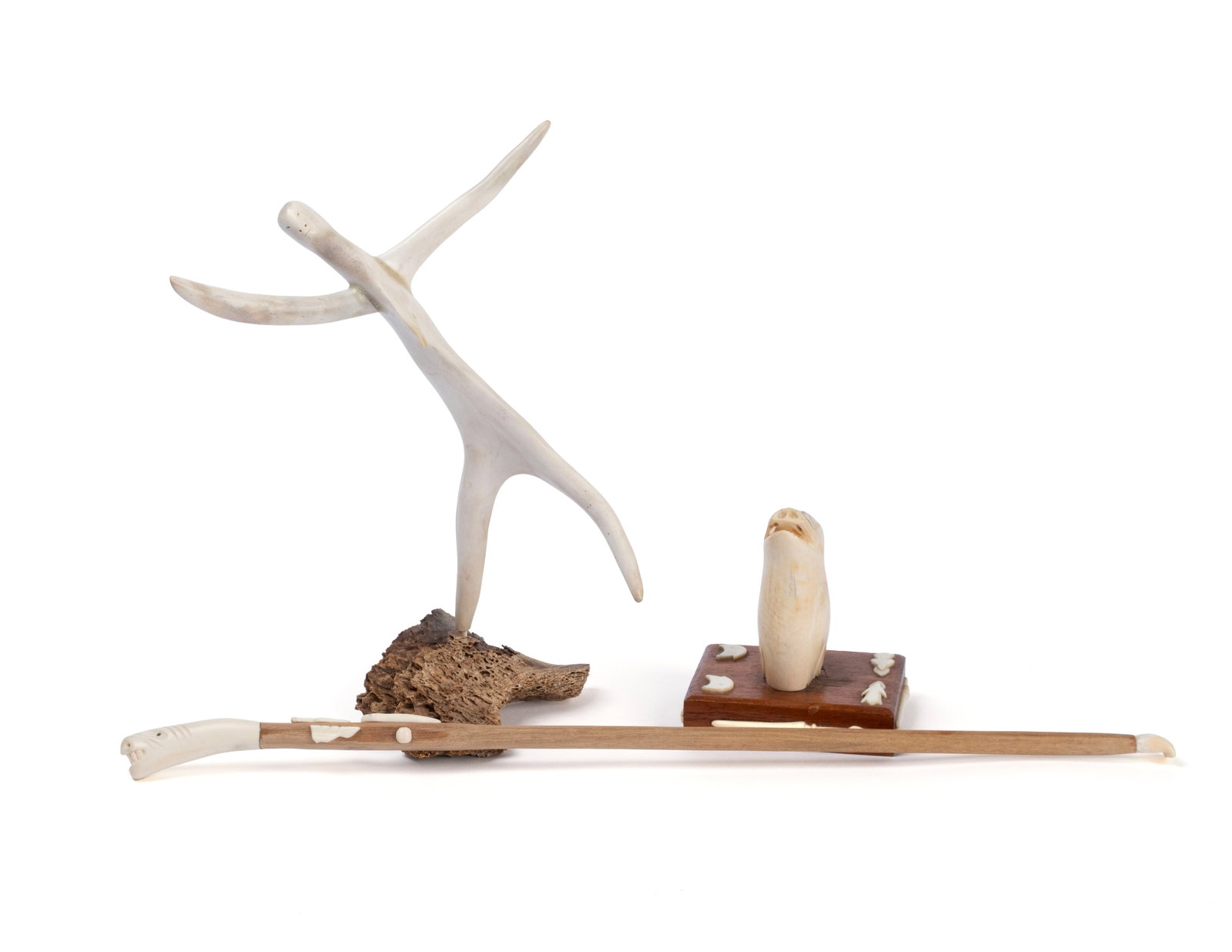 THREE GREENLANDIC INUIT CARVINGS: THREE GREENLANDIC INUIT CARVINGS Greenland, 20th century, carved bone. Including an Inuit dancer signed illegibly in Inuktitut, a seal head on stand, unsigned, and a figural back scratcher. Dancer 9 1