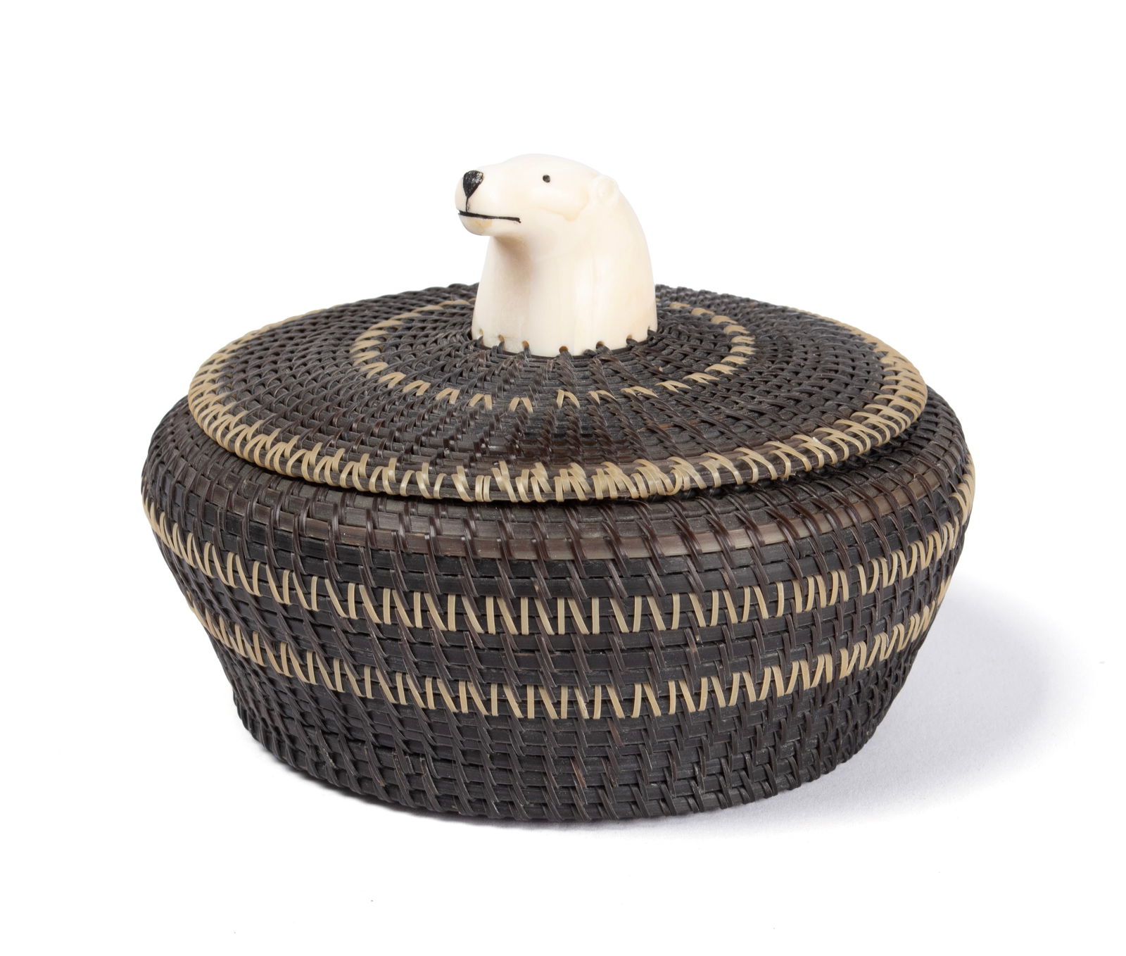 ANDREW OENGA (INUPIAT, 20TH C.): Andrew OengaInupiat, 20th c.Bone and baleenSigned to the interior bottom with Barrow Alaska and dated 1973. Woven baleen basket with bone finial in the shape of a bear's head.3.7 x 5.1 x 5.1 in. (9.4