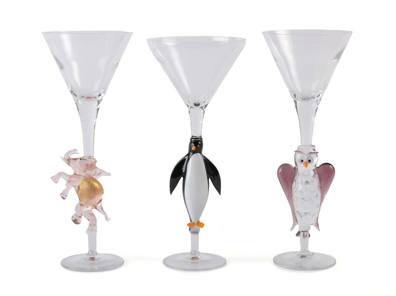 THREE VENETIAN FIGURAL MARTINI GLASSES: THREE VENETIAN FIGURAL MARTINI GLASSESPossibly Murano. With figural stems in the form of a pink elephant, an owl, and a penguin.10 in. (25.4 cm.)