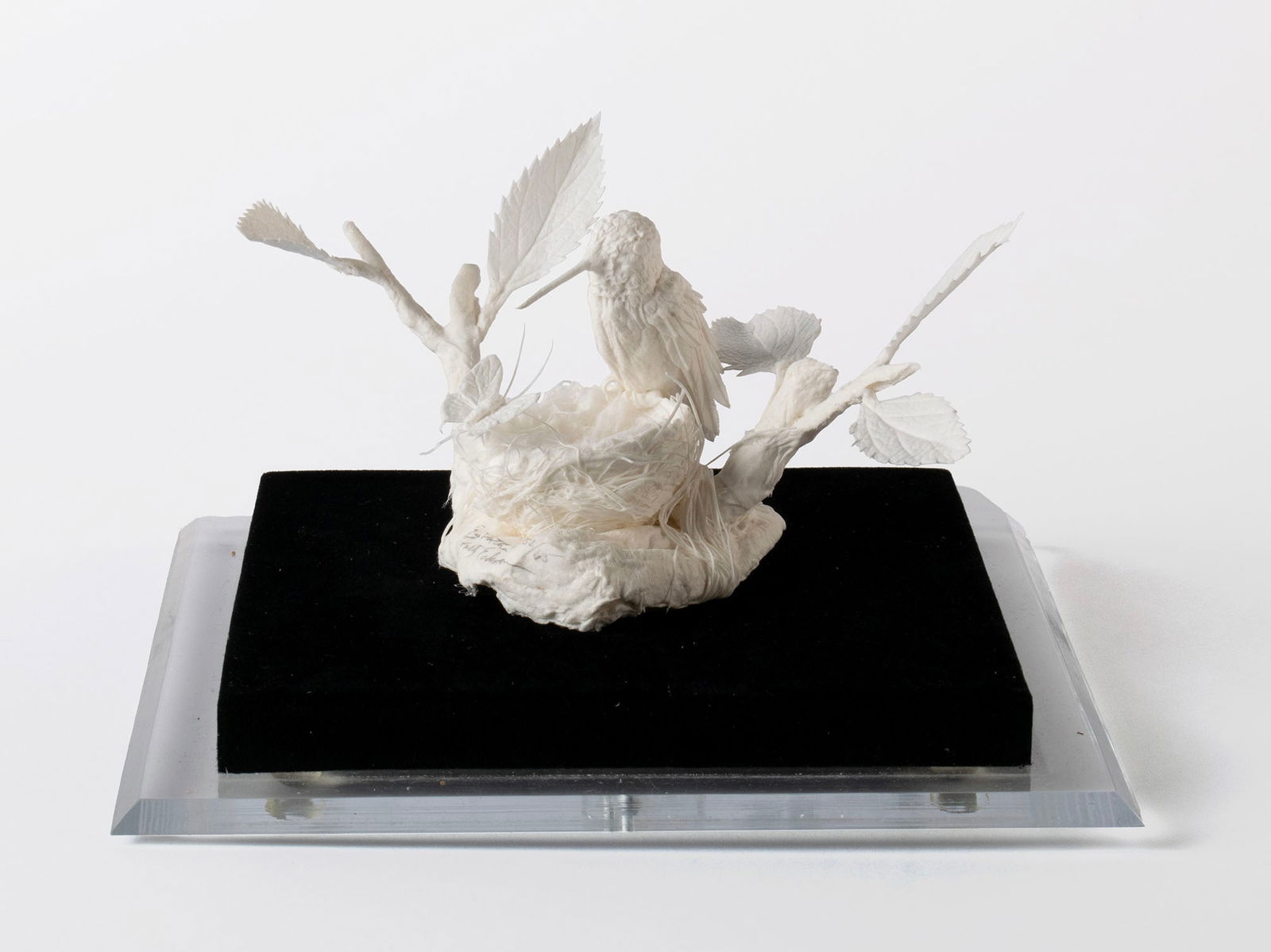 PATTY ECKMAN PAPER SCULPTURE: PATTY ECKMAN PAPER SCULPTURESigned, titled "Egg Watch II", and numbered 52/65 on base. Hummingbird watching over its nest on a branch, encased.Sculpture: 3 1/2 x 6 x 4 3/4 in. (8.9 x 15.2 x 12.1 cm.),