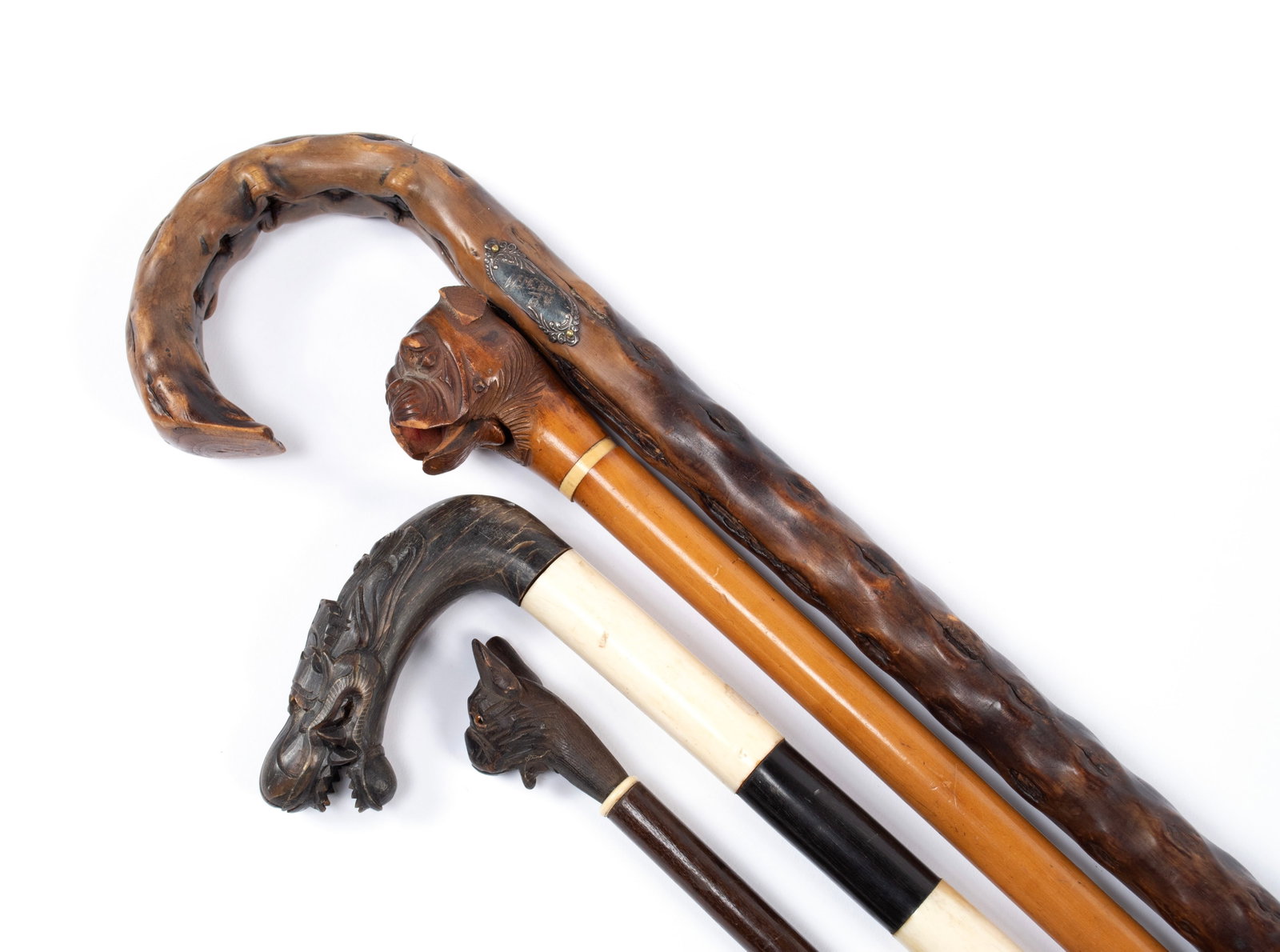 COLLECTION OF CANES: COLLECTION OF CANES 19th/early 20th century. Four canes including two carved wood bulldog canes, a stick cane, and a Chinese horn and bone dragon cane. Longest: 36 in. ( x 91.4 cm.)