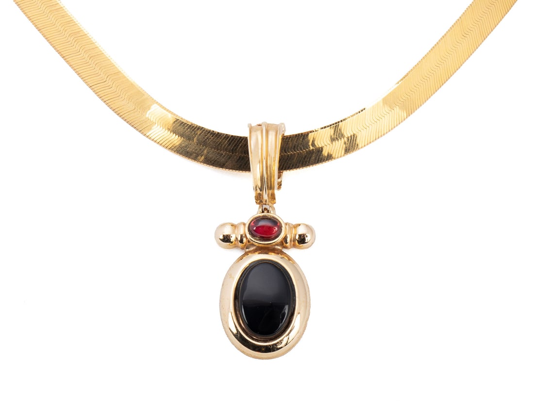 ONYX & RUBY GOLD PENDANT NECKLACE: ONYX & RUBY GOLD PENDANT NECKLACE A 10k yellow gold herringbone chain (14 grams) with an onyx and garnet pendant, marked 14k to bale. Length: 18 in. (45.7 cm.); 21 grams