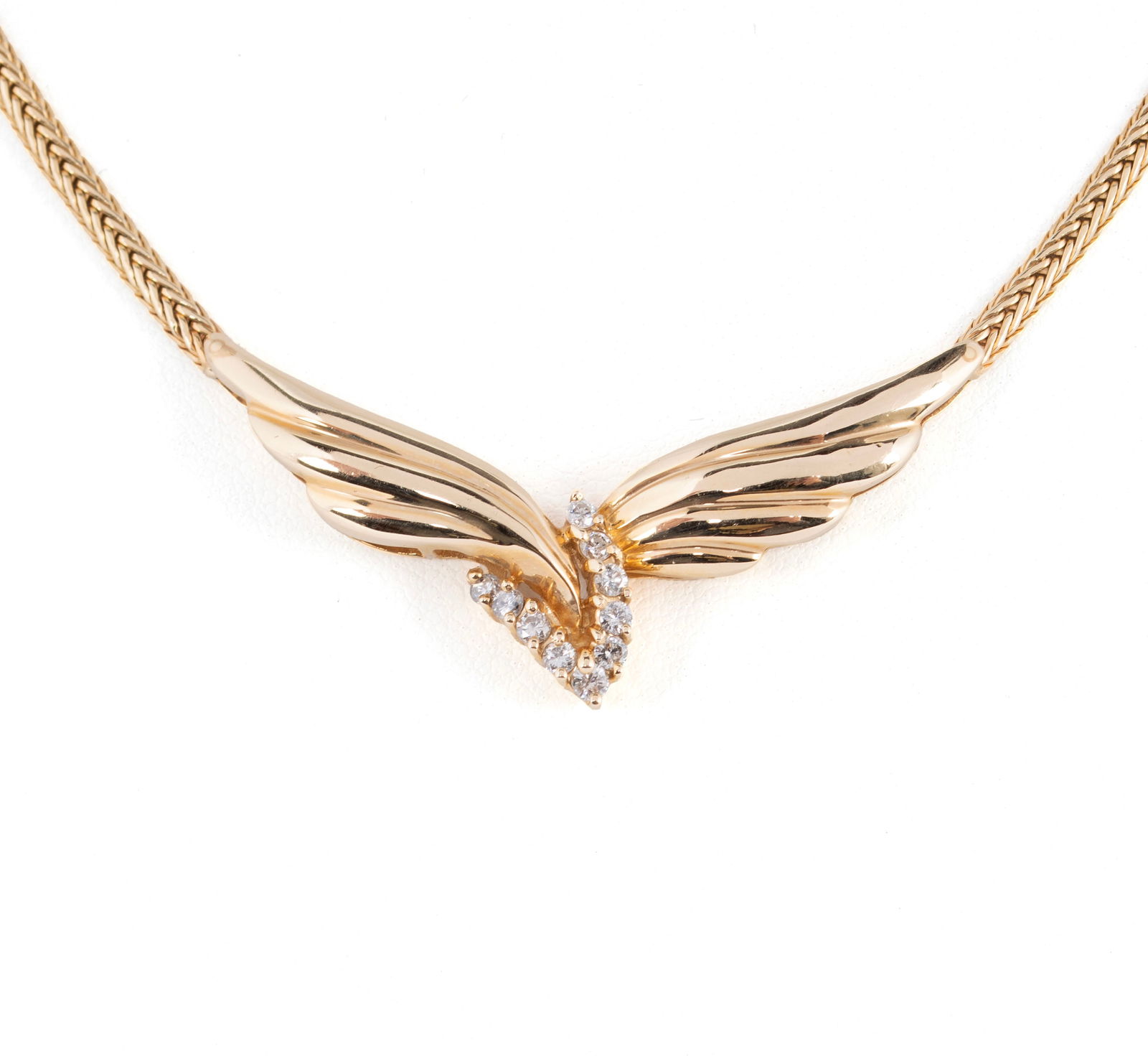 WINGS YELLOW GOLD PENDANT NECKLACE: WINGS YELLOW GOLD PENDANT NECKLACE A 14k yellow gold foxtail chain with box clasp, joined by a wing form pendant centered by ten (10) round brilliant diamonds weighing approximately 0.30ctw. in a