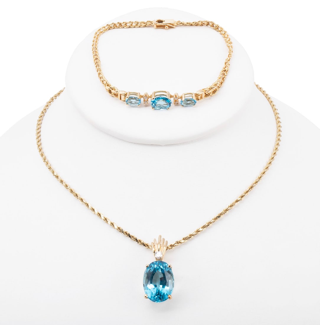 BLUE TOPAZ, DIAMOND, & YELLOW GOLD NECKLACE AND BRACELET SET: BLUE TOPAZ, DIAMOND, & YELLOW GOLD NECKLACE AND BRACELET SET A 14k yellow gold rope chain with 14k yellow gold pendant set with oval faceted blue topaz measuring 15.2mm x 11.2mm with a single round
