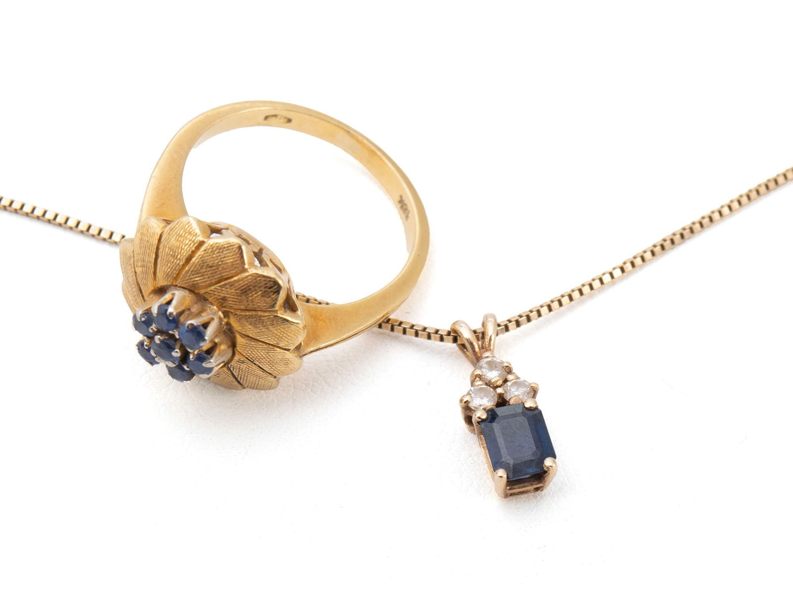 GOLD SAPPHIRE RING & PENDANT NECKLACE: GOLD SAPPHIRE RING & PENDANT NECKLACE An 18k yellow gold ring set with seven (7) round faceted sapphires measuring 2mm each. A 14k yellow gold box chain suspending one (1) yellow gold pendant set