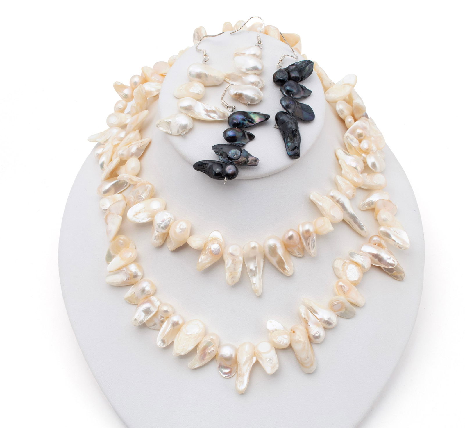 BAROQUE PEARL NECKLACE AND EARRINGS: BAROQUE PEARL NECKLACE AND EARRINGSA hand-knotted white elongated baroque pearl necklace (approx. 8-11mm), accompanied by two (2) pair of matching earrings, one (1) of white pearls and one (1) of blac