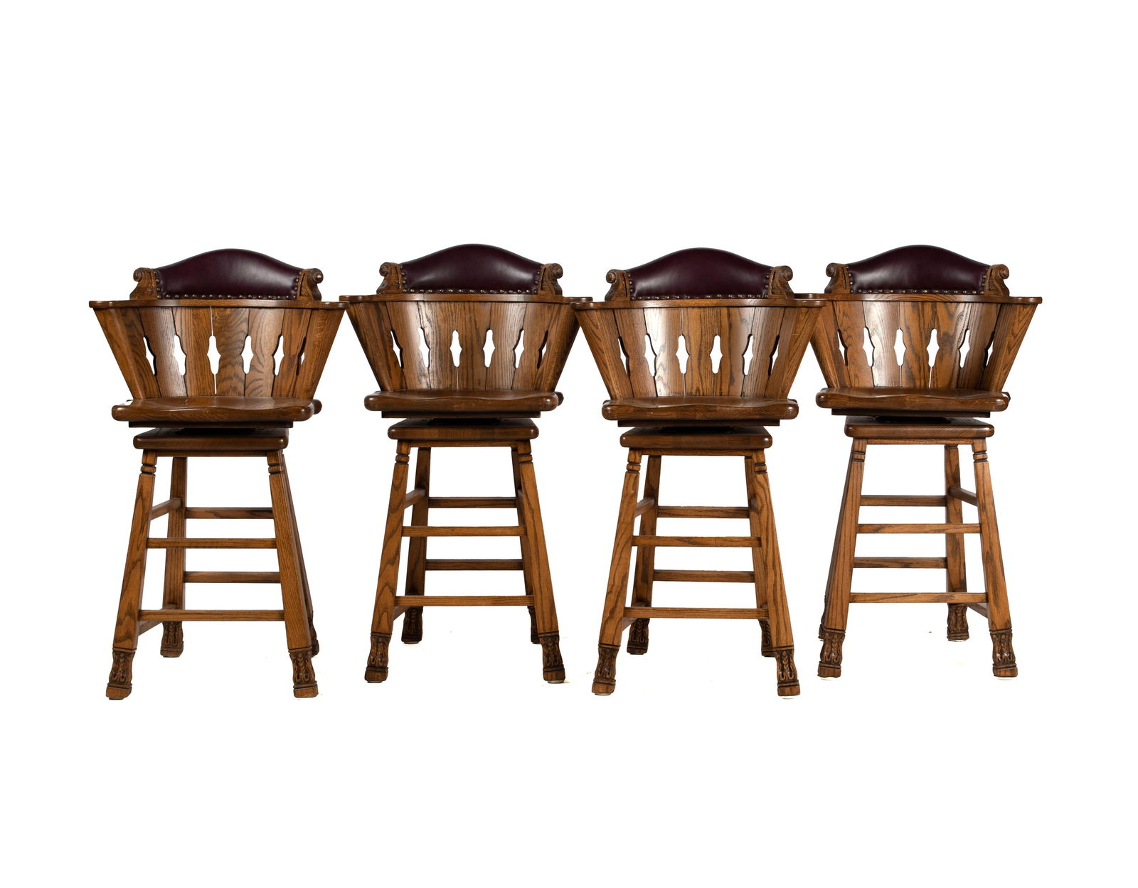 SET OF FOUR ROMWEBER VIKING OAK SWIVEL BAR STOOLS: SET OF FOUR ROMWEBER VIKING OAK SWIVEL BAR STOOLS American, 3rd quarter 20th century. Pierced barrel backs with brass tack upholstered cordovan leather top rails, over saddle seats on tapering square