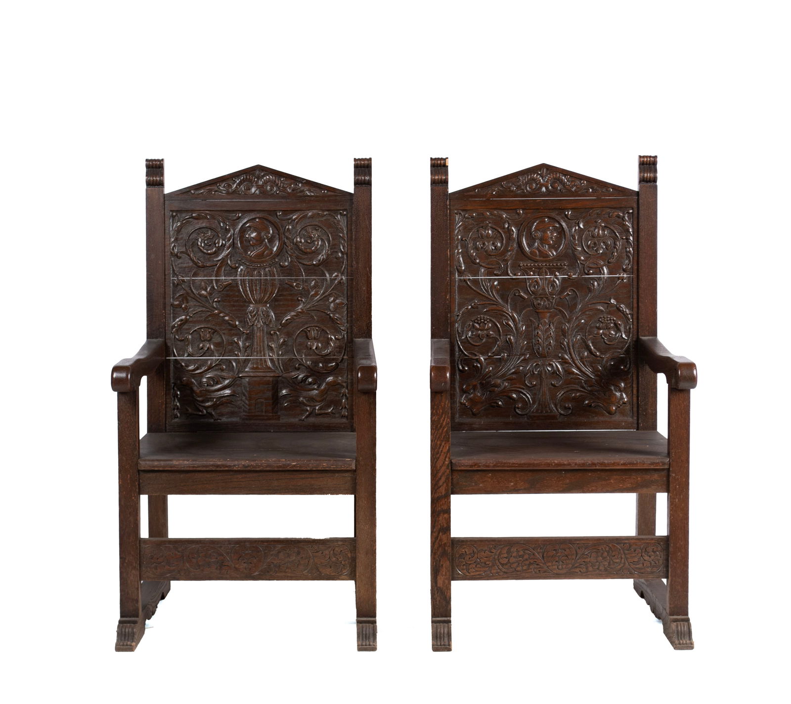 PAIR OF OAK OPEN ARMCHAIRS: PAIR OF OAK OPEN ARMCHAIRS American, early 20th century. Solid carved panel backs over the plank seats, on straight legs connected by stretchers. Each: 43 1/2 x 23 1/2 x 26 in. (110.5 x 59.7 x 66 cm.)
