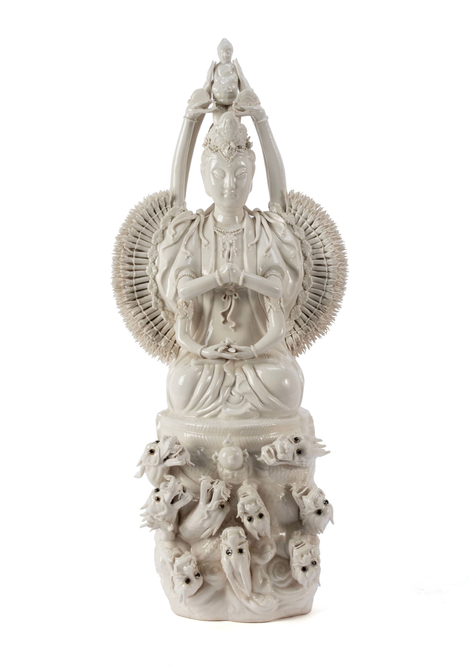 BLANC DE CHINE BODHISATTVA: BLANC DE CHINE BODHISATTVA Chinese, 20th century. Depicts Quan Yin, the goddess of compassion, in the thousand-arm form with a figure on her head and many dragon heads low to the front. 24 x 12 in.