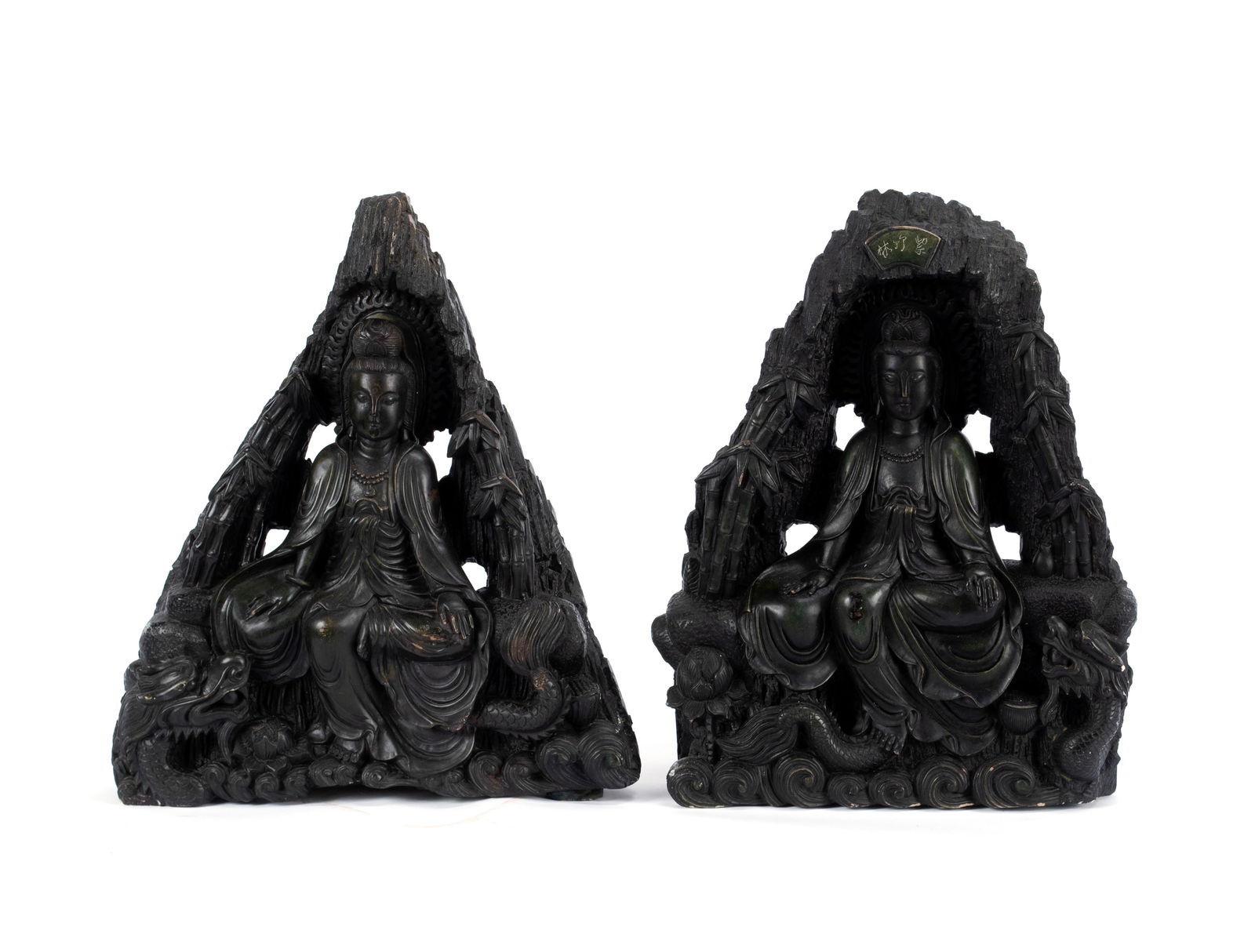PAIR OF QUAN YIN FIGURAL STATUES: PAIR OF QUAN YIN FIGURAL STATUES Chinese, 20th century, carved and stained stone with a dark green patina. Triangular form shown in a seated position with dragons below their feet. First: 18 1/2 x 16