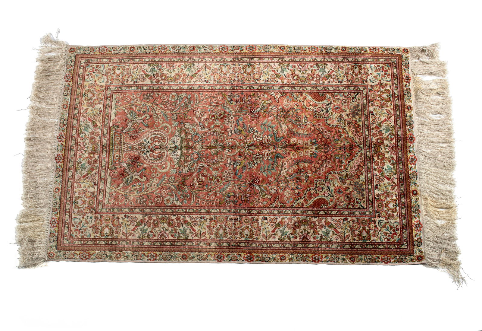 DIRECTIONAL SILK PRAYER RUG: DIRECTIONAL SILK PRAYER RUG Turkish, 20th century, all silk. Flowering urn with floral filled trees flanking skyward on the red ground with soft green upper corners, ivory border with multiple guard