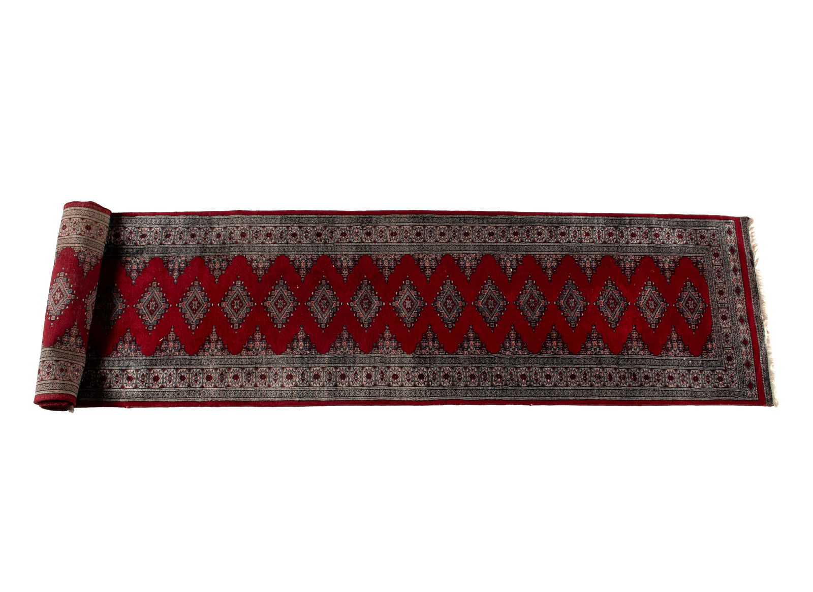 BOKHARA LONG RUG: BOKHARA LONG RUG Pakistani, 3rd quarter 20th century. Good soft weave of a repetitive design of medallions running the red field, foliate border with multiple guard borders with red surround. 15 ft.