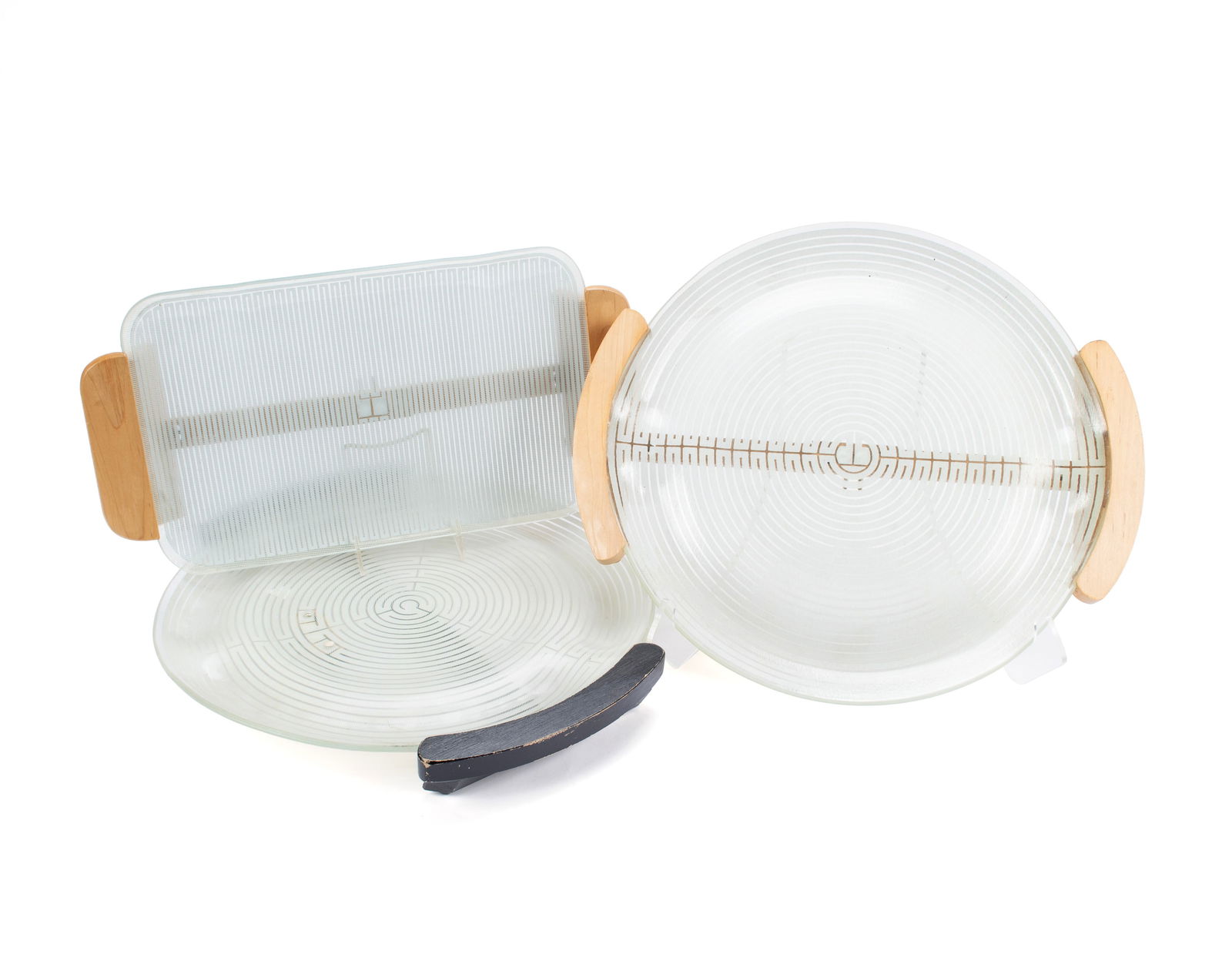 RUSSELL WRIGHT DESIGNED WARMING TRAYS: RUSSELL WRIGHT DESIGNED WARMING TRAYS Mid 20th century. Two (2) glass trays with blond wood handles, one (1) marked for Temprex Glass Corporation and the other for Electriglas, and a round tray with