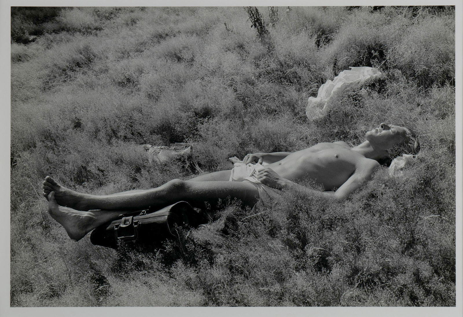 TOD PAPAGEORGE (AMERICAN, B. 1940): Tod PapageorgeAmerican, b. 1940Central Park, 1983PhotographSigned, titled and dated to verso. Image of a semi-nude man lying in a field, framed.Image: 12 1/2 x 18.69 in. (31.8 x 47.5 cm.), Frame: 21 1