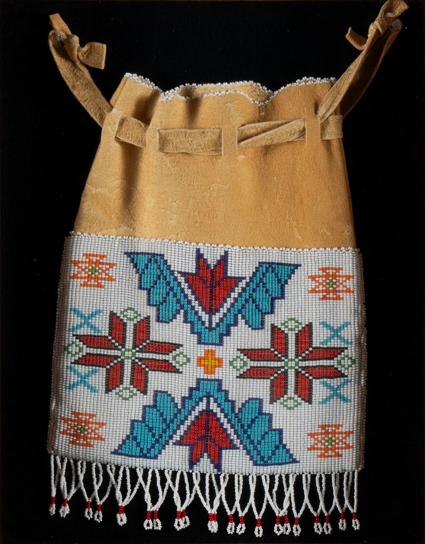 PLAINS NATIVE AMERICAN BEADED LEATHER TOBACCO POUCH: PLAINS NATIVE AMERICAN BEADED LEATHER TOBACCO POUCH 20th century. Geometric designs and dangling tassels, mounted within a modern shadow box. 14 3/4 x 11 3/4 in. (37.5 x 29.8 cm.)
