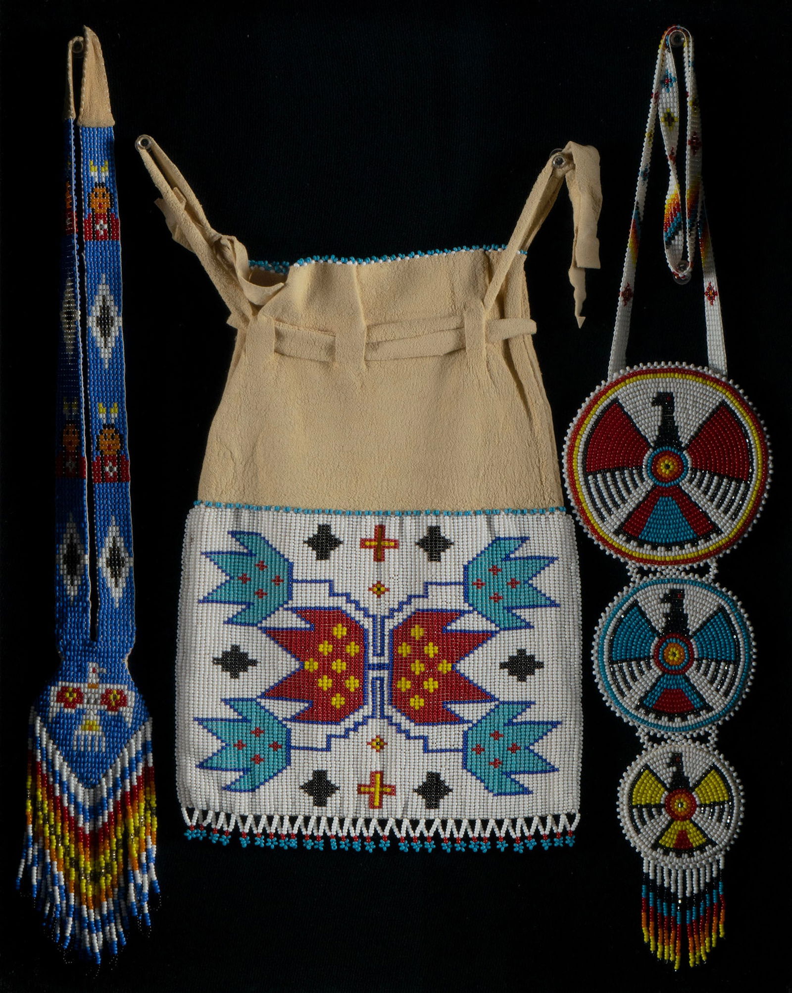 NATIVE AMERICAN BEADED TOBACCO POUCH AND TWO SASHES: NATIVE AMERICAN BEADED TOBACCO POUCH AND TWO SASHES 20th century. Leather pouch decorated with geometric forms, with two colorful sashes decorated with bird forms and geometric designs, mounted