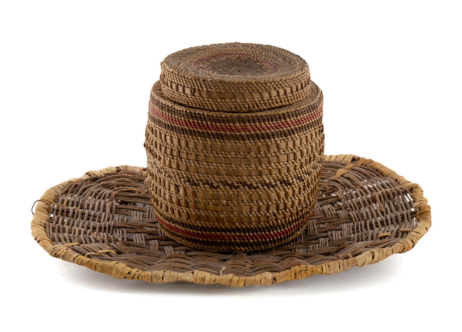 TWO NATIVE AMERICAN BASKETS: TWO NATIVE AMERICAN BASKETS20th century. Hopi piki tray having Fenn Gallery of Santa Fe tag together with a Makah/Nootka lidded trinket basket.Tray: 12 x 10 in. (30.5 x 25.4 cm.), Trinket: 5 1/4 x 5 1