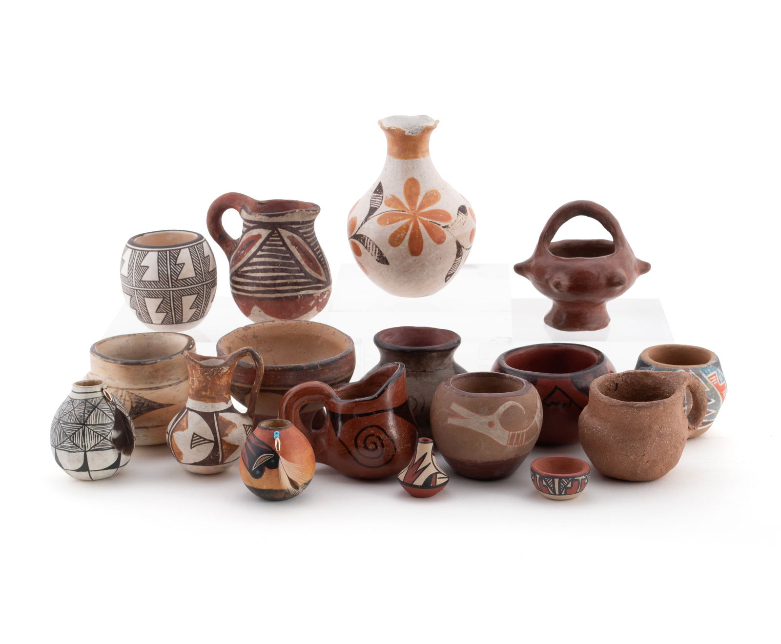 SEVENTEEN DIMINUTIVE NATIVE AMERICAN VESSELS: SEVENTEEN DIMINUTIVE NATIVE AMERICAN VESSELSAmerican, 20th century. Fifteen (15) assorted pottery vases including an Acoma jar by Rebecca Lucario, together with two (2) small gourd vases with attached