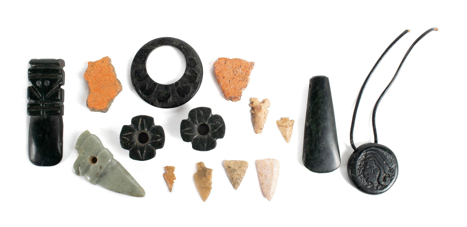 STONE AND MINERAL CARVINGS: STONE AND MINERAL CARVINGSMesoamerican. Several carved minerals including floriform, a pierced blade form bloodletter, discs six diminutive arrowheads and two shards.Largest: 2 3/4 x 1 in. (7 x 2.5 cm