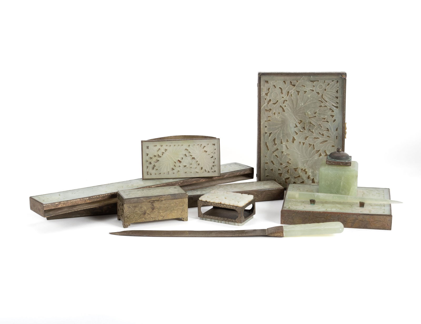 CHINESE JADE AND BRASS DESK SET: CHINESE JADE AND BRASS DESK SET20th century. Nine (9) pieces including an inkwell on stand with pen, a letter opener, two blotter ends, blotter, matchbox holder and two lidded boxes.Blotter end: 12 x