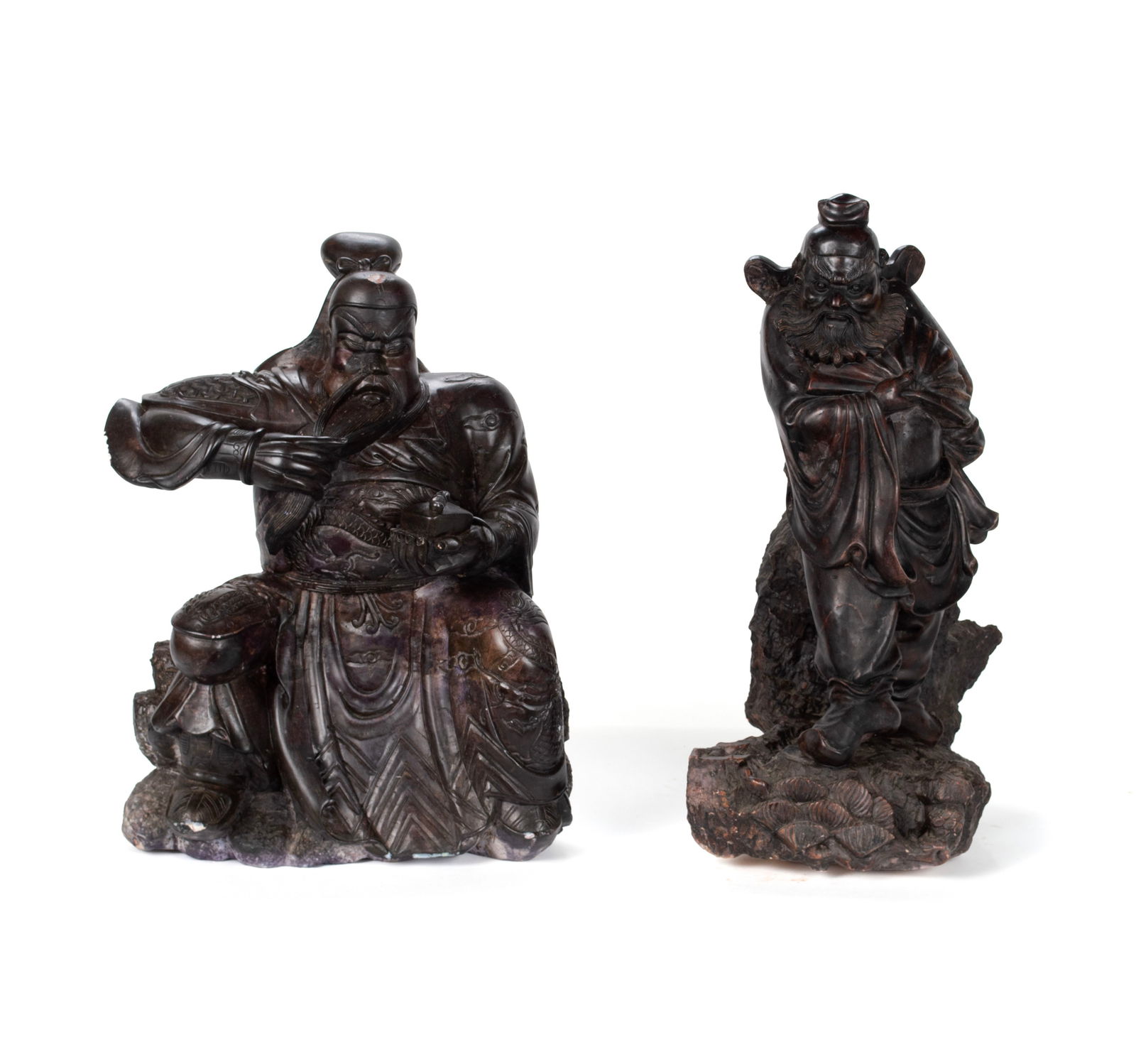 TWO CHINESE SCUPTURES OF AN ELDER AND A WARRIOR: TWO CHINESE SCUPTURES OF AN ELDER AND A WARRIORChinese, 20th century, carved and brown stained stone. One a standing figure of an elder in a robe holding a fan. The other a god-like seated figure hold