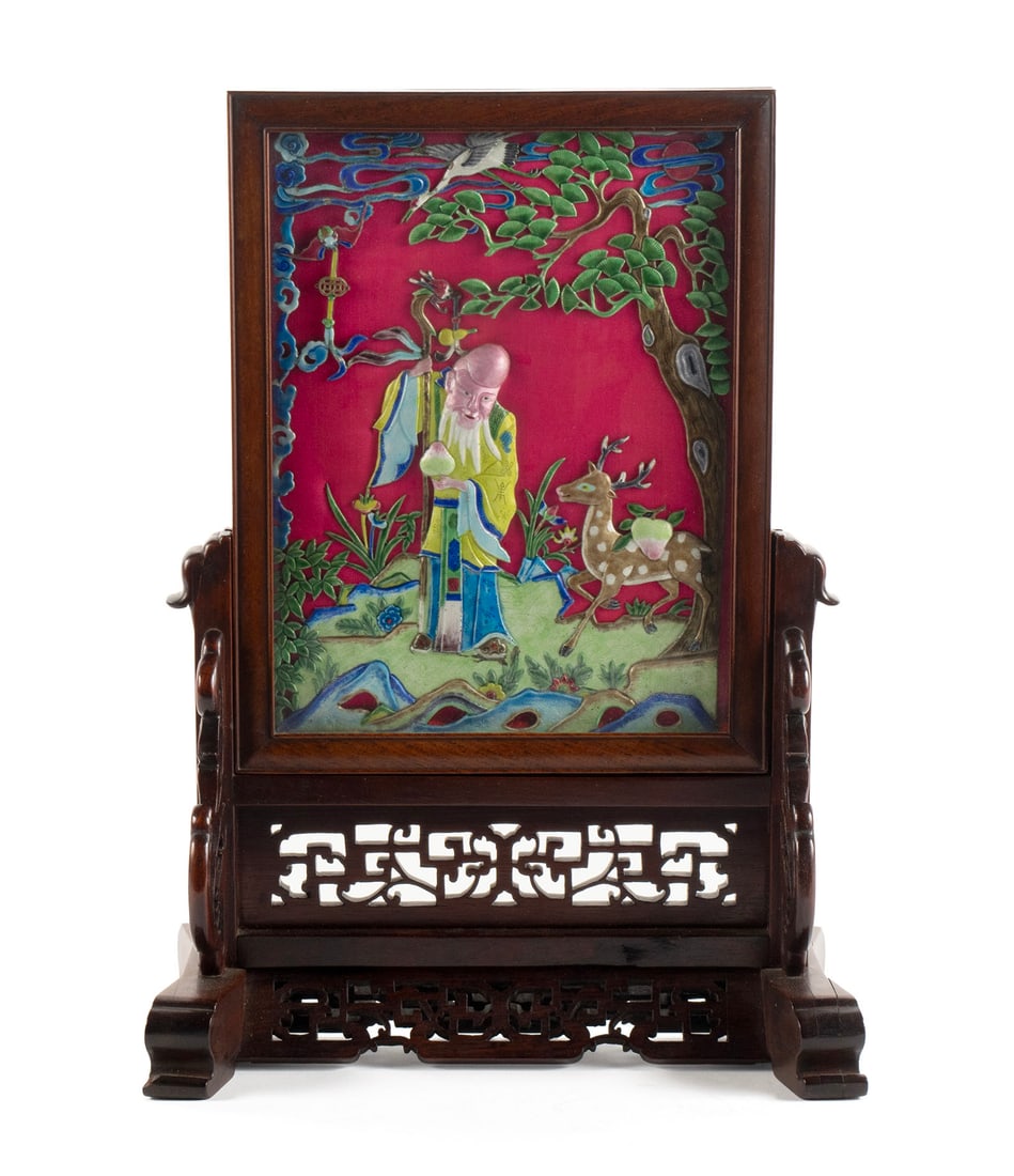 CHINESE ENAMELED TABLE SCREEN: CHINESE ENAMELED TABLE SCREEN20th century. Cloisonne enamel panel depicting shoulao, deer and symbols on longevity, on a silk background, in a wooden carved frame.16 1/2 x 12 x 6 in. (41.9 x 30.5 x 15