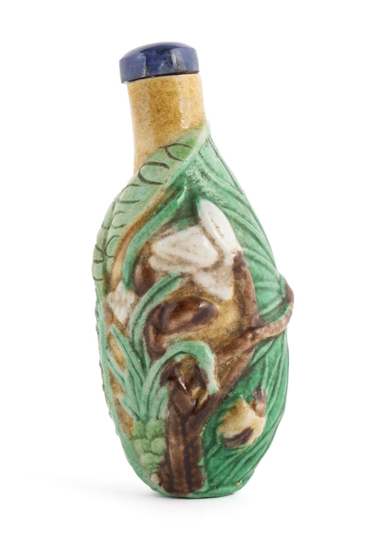 CHINESE PORCELAIN LOTUS SNUFF BOTTLE: CHINESE PORCELAIN LOTUS SNUFF BOTTLECirca 1860-1920. Enamel decorated "Lotus-Wrapped" snuff bottle having sodalite stopper.3 in. (7.6 cm.)