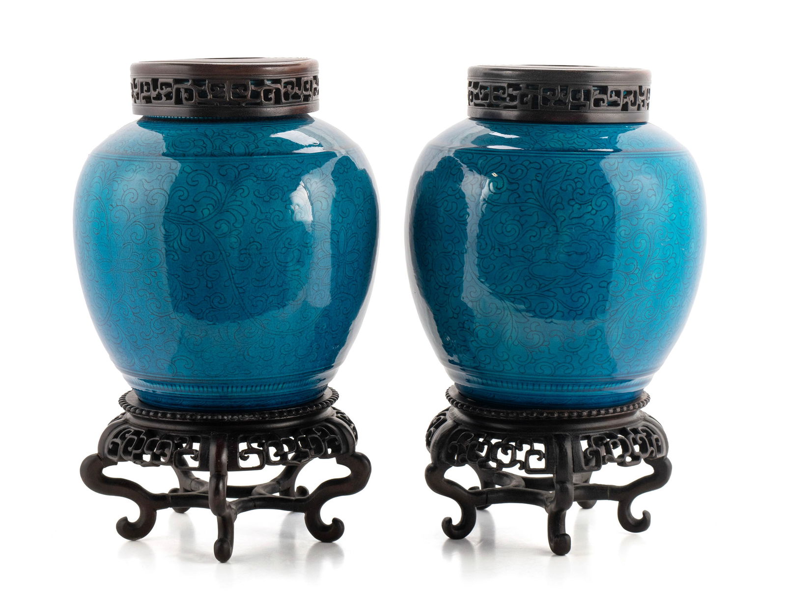 PAIR OF BLUE CHINESE PORCELAIN GINGER JARS: PAIR OF BLUE CHINESE PORCELAIN GINGER JARSChinese, 20th century. Incised floral decorated jars with carved wood stands and lids.10 1/2 x 9 in. (26.7 x 22.9 cm.), Height overall: 15 in. (38.1 cm.)