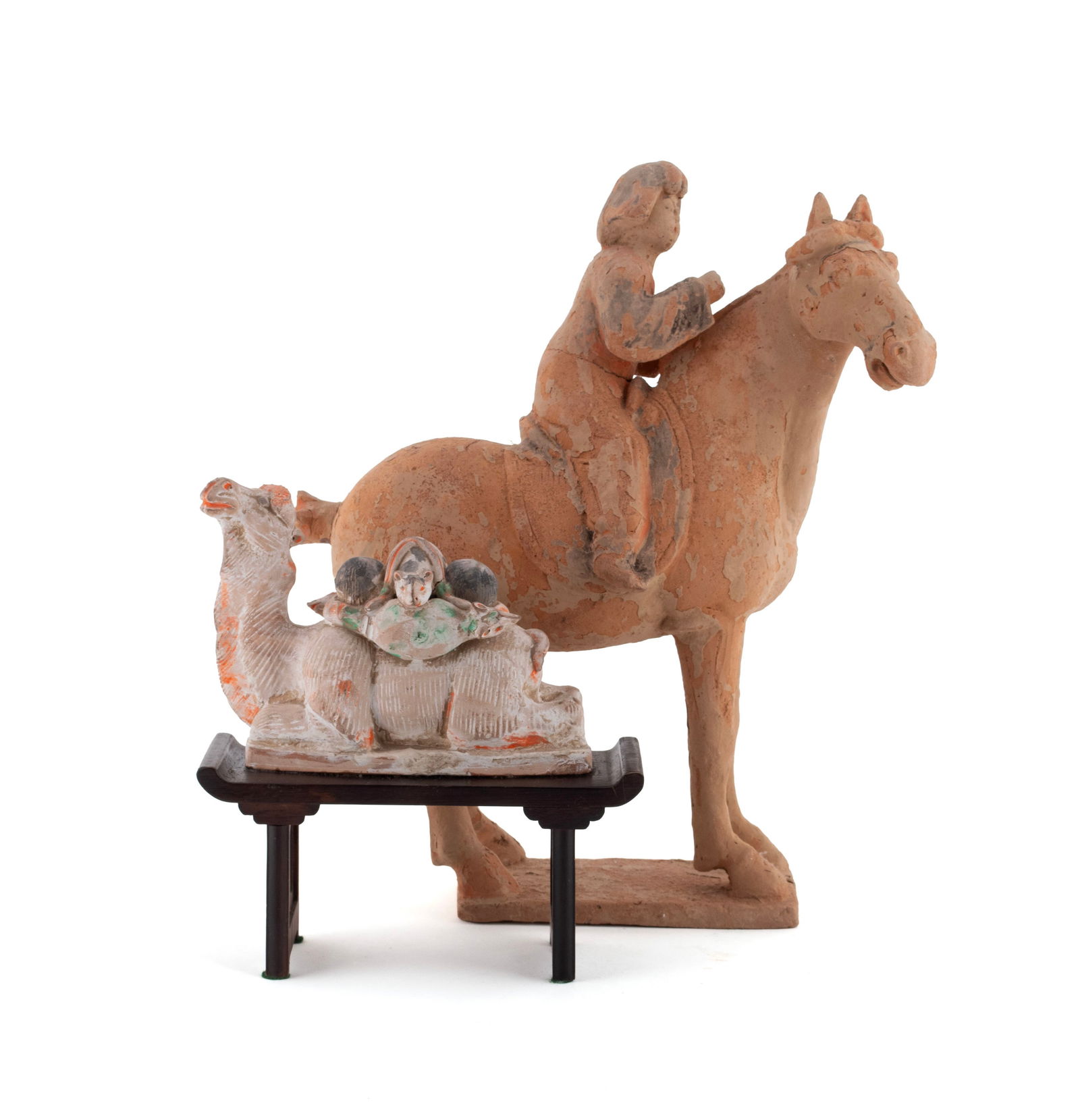 TWO TANG STYLE TERRACOTTA FIGURES: TWO TANG STYLE TERRACOTTA FIGURESTwo terracotta tomb figures including a horse and rider, and a camel with loaded saddle, mounted on a wooden stand.Larger: 14 1/4 x 13 1/4 x 5 in. (36.2 x 33.7 x 12.7