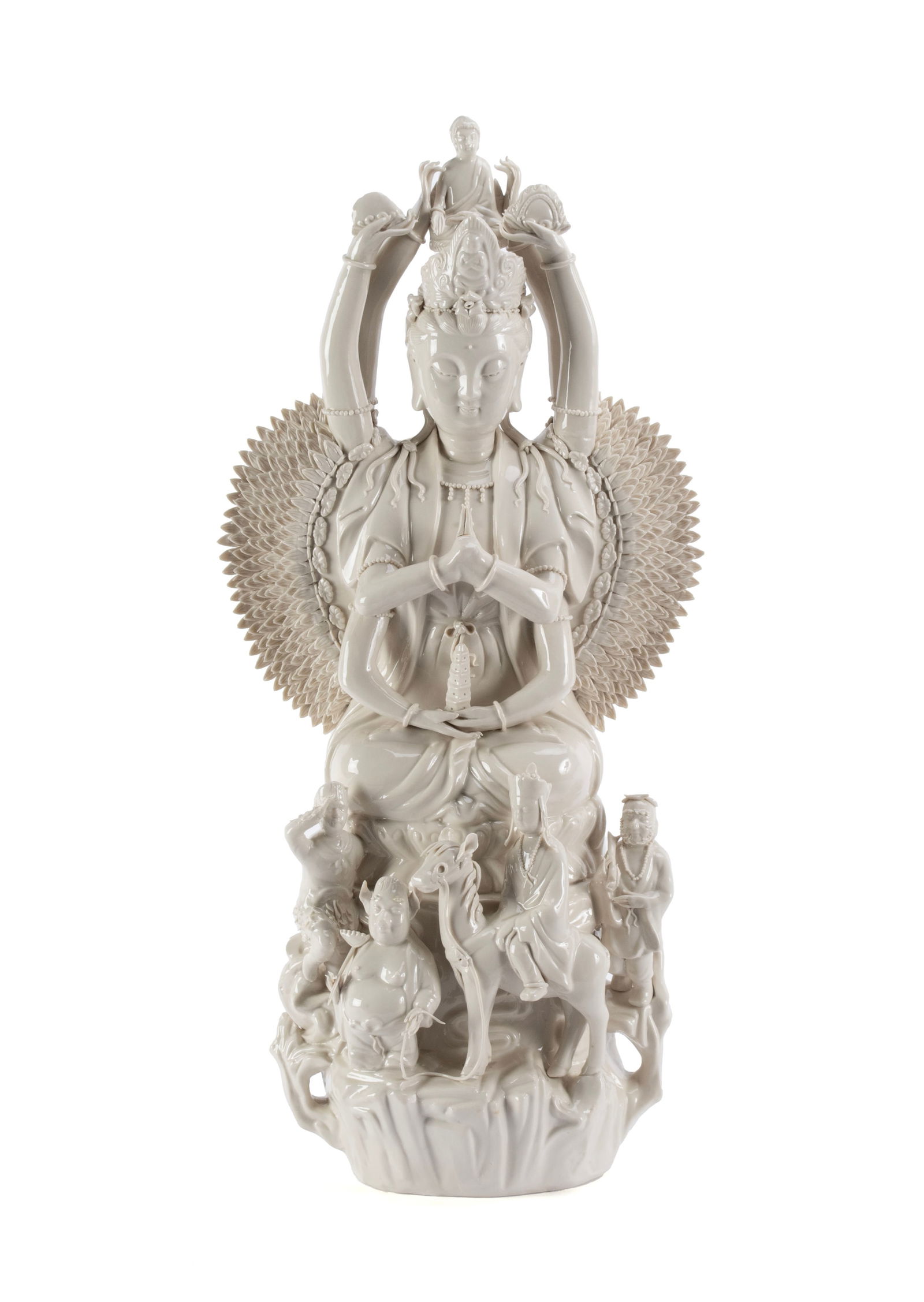 BLANC DE CHINE QUAN YIN: BLANC DE CHINE QUAN YINChinese, 20th century. Depicts a seated Quan Yin, the goddess of compassion in the thousand hand form, with a figure on her head and low across the front, one a top a horse.26 x