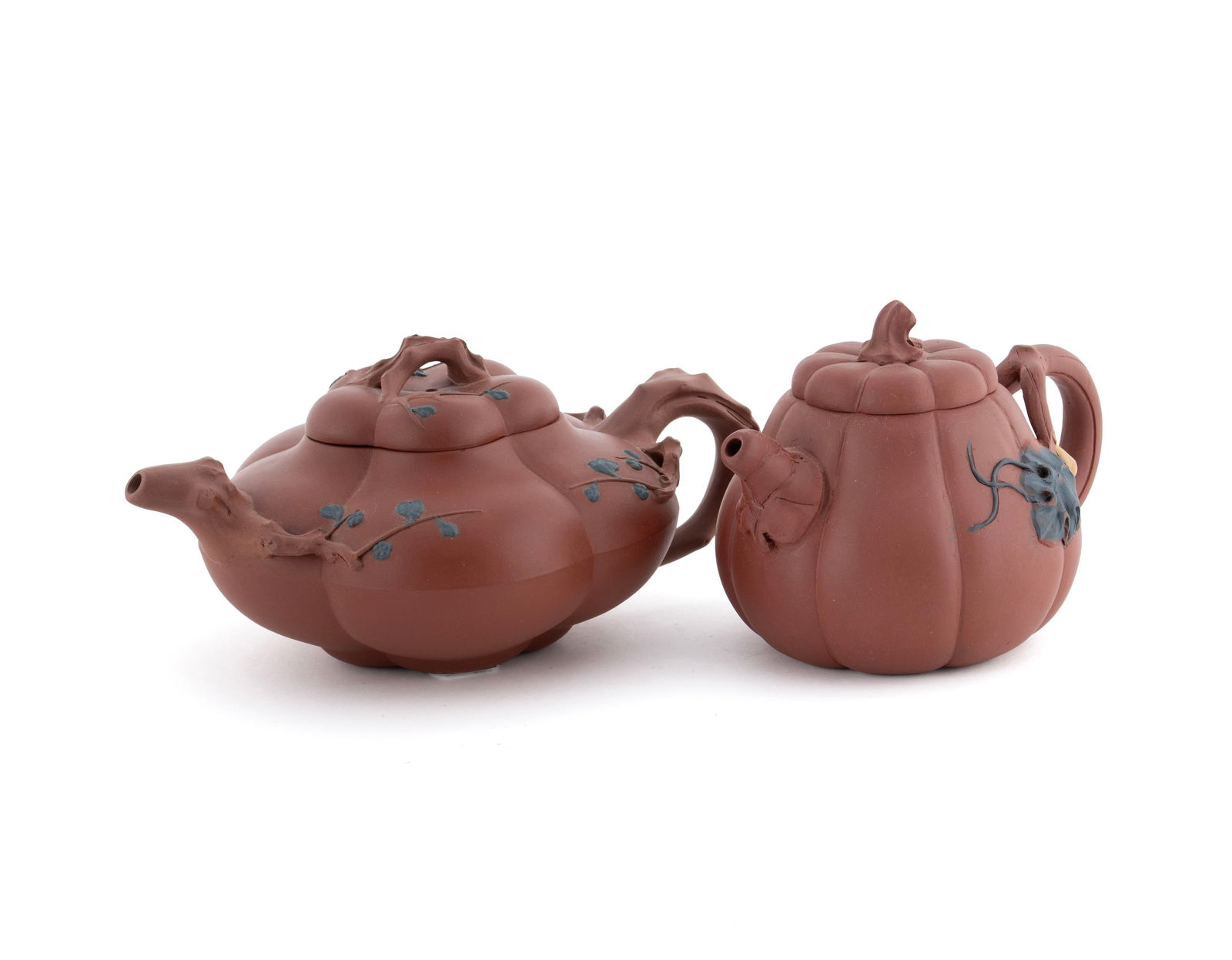 TWO YIXING TEAPOTS: TWO YIXING TEAPOTS20th century. Both of lobed, melon form, one with prunus decoration, marked to lid interior, and the other marked on underside.Larger: 3 3/4 x 8 1/2 x 6 in. (9.5 x 21.6 x 15.2 cm.)