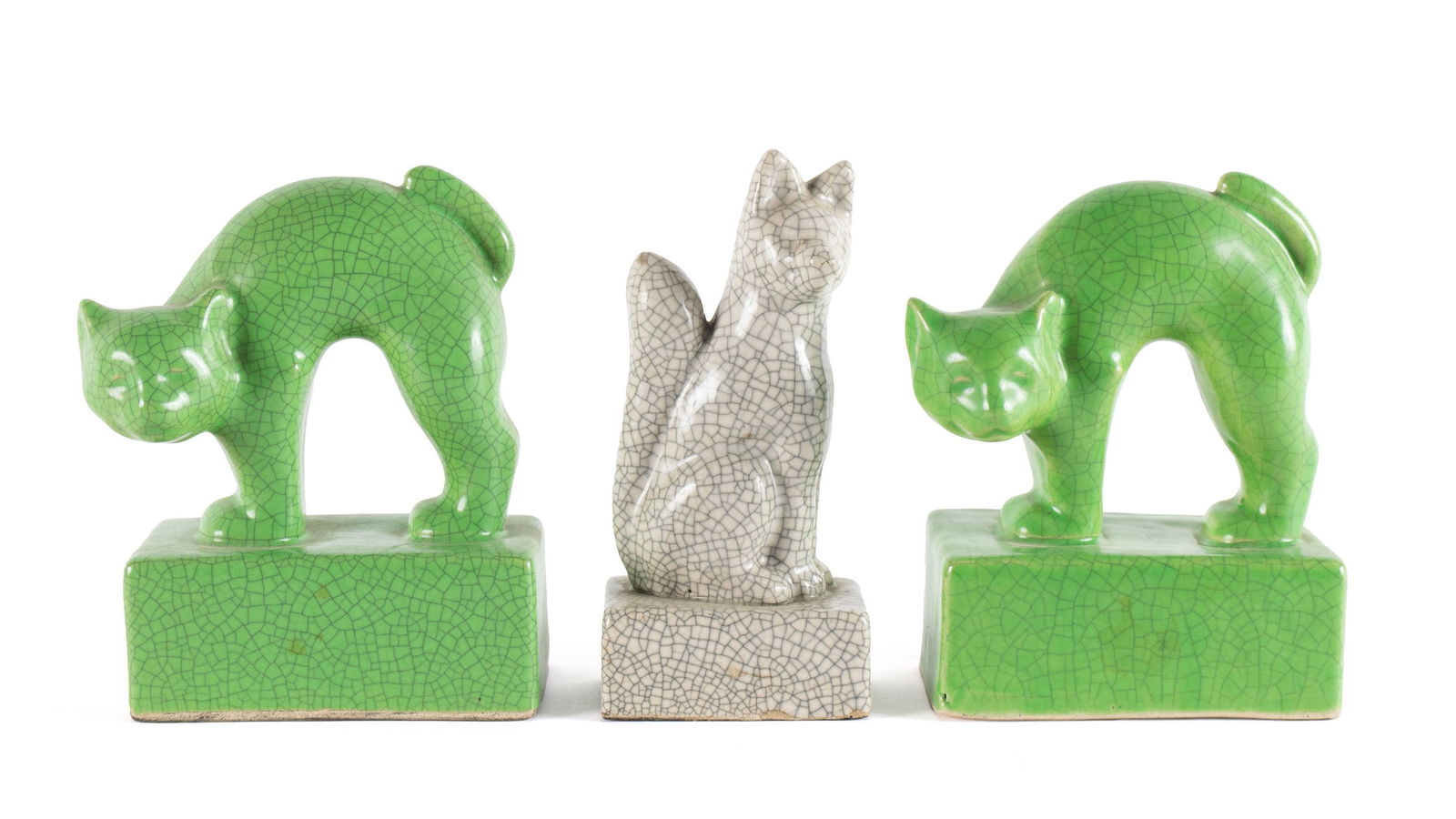 THREE JAPANESE CRACKLE GLAZE PORCELAIN FIGURES: THREE JAPANESE CRACKLE GLAZE PORCELAIN FIGURESMid-20th century. Pair of green cat form bookends together with a figural fox.Cats 6 1/4 x 3 x 5 in. (15.9 x 7.6 x 12.7 cm.), Fox 6 1/2 x 2 x 3 in. (16.5