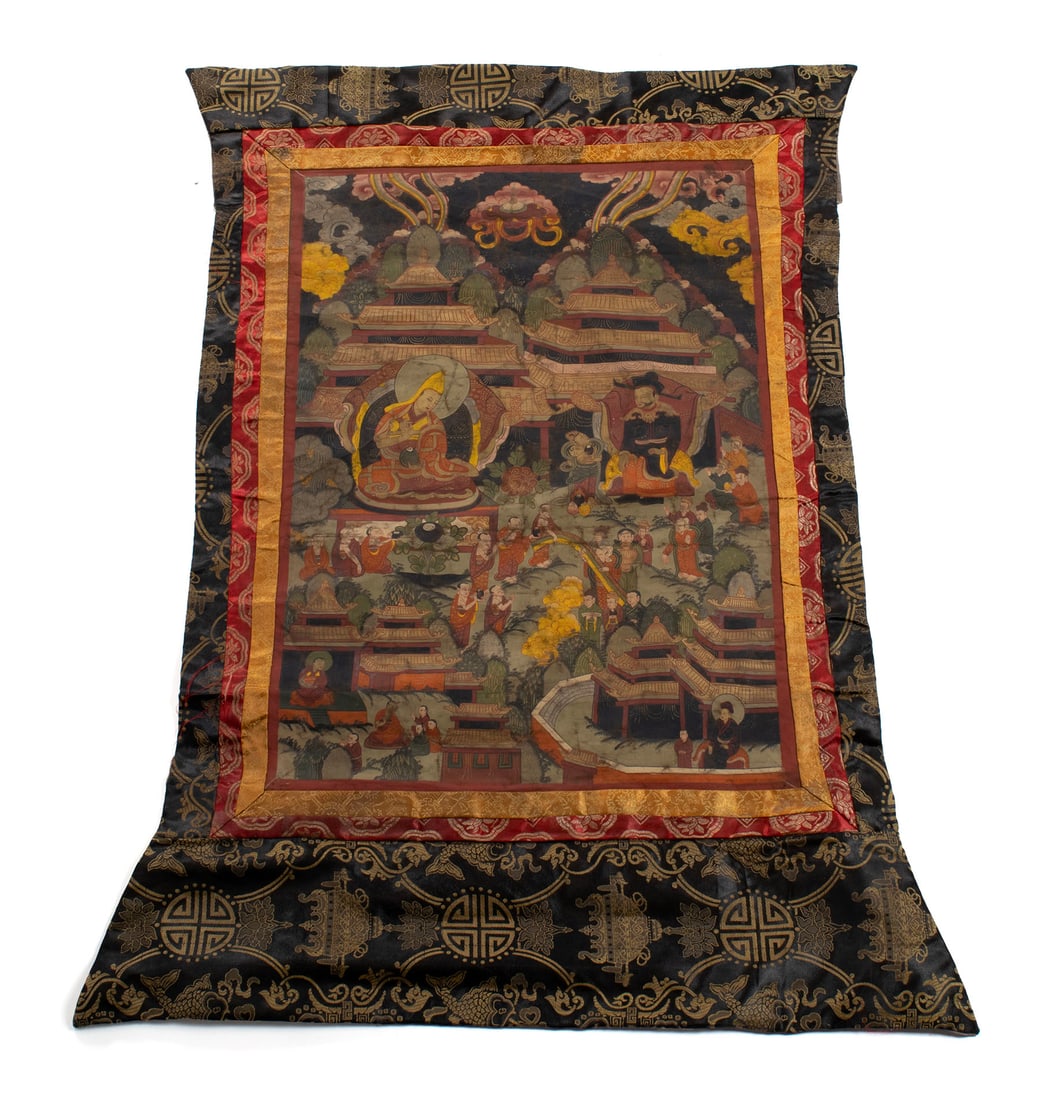 TIBETAN THANGKA: TIBETAN THANGKA Tibetan, late 19th/early 20th century, paint on linen with silk brocade border. Showing two central figures of an Arhat and Lama surrounded by Lama/deities within garden surrounded by
