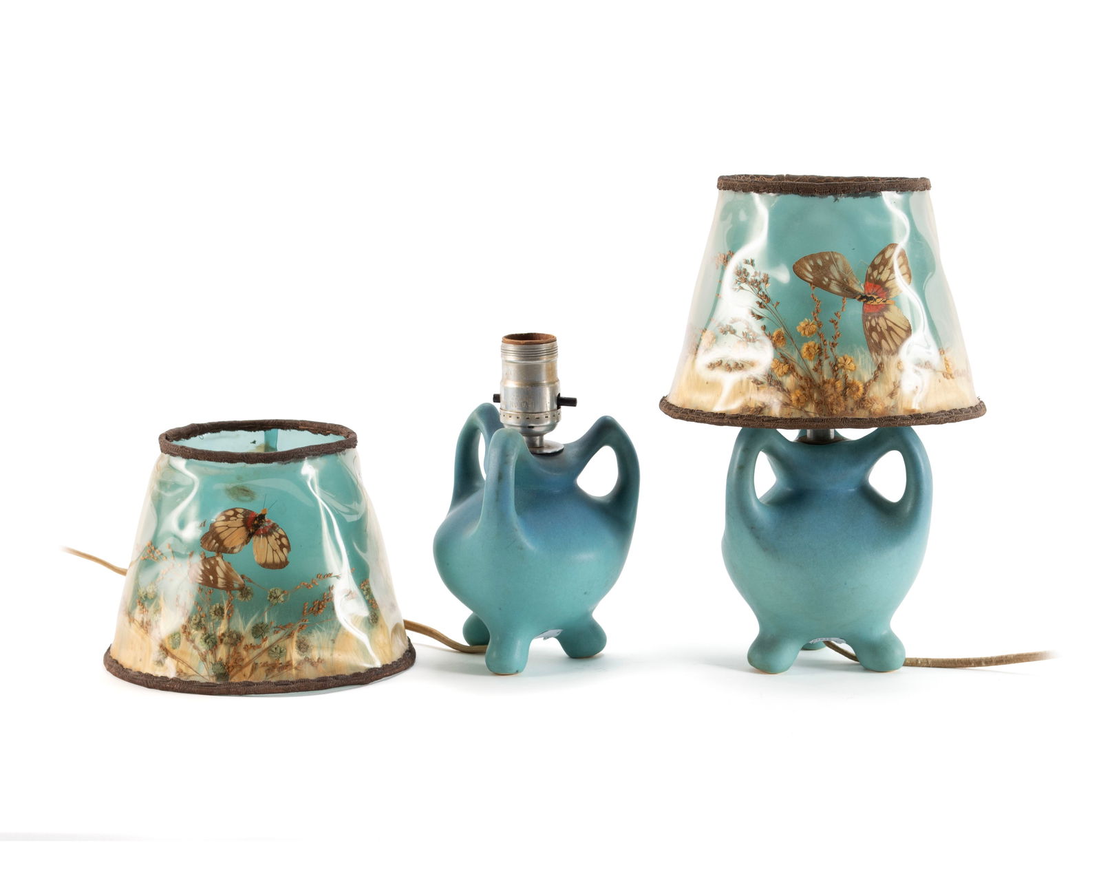 PAIR OF VAN BRIGGLE POTTERY LAMPS WITH ORIGINAL SHADES: PAIR OF VAN BRIGGLE POTTERY LAMPS WITH ORIGINAL SHADESAmerican, early 20th century. Pair of three-handled blue glaze lamp bases, marked on feet, with original shades.Overall: 11 1/2 in. (29.2 cm.)
