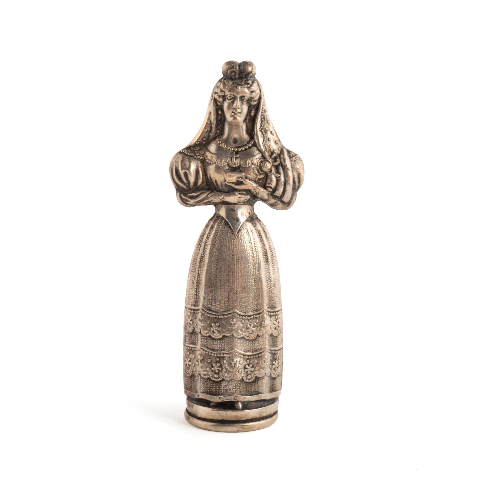 FRENCH SILVER-PLATE FIGURAL NEEDLE CASE: FRENCH SILVER-PLATE FIGURAL NEEDLE CASE19th century. Standing figure of a woman in dress with arms up to chest holding book, unmarked.3 in. (7.6 cm.)