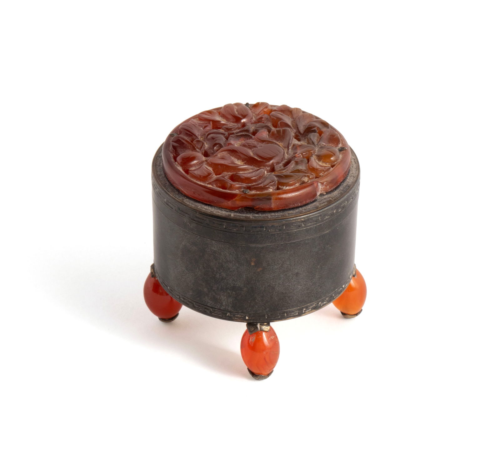 EDWARD FARMER STERLING SILVER AND CARNELIAN STAMP BOX: EDWARD FARMER STERLING SILVER AND CARNELIAN STAMP BOXAmerican, early 20th century. Round sterling silver box with stamp slit having foliate carved Carnelian inset lid, resting on four Carnelian bead f